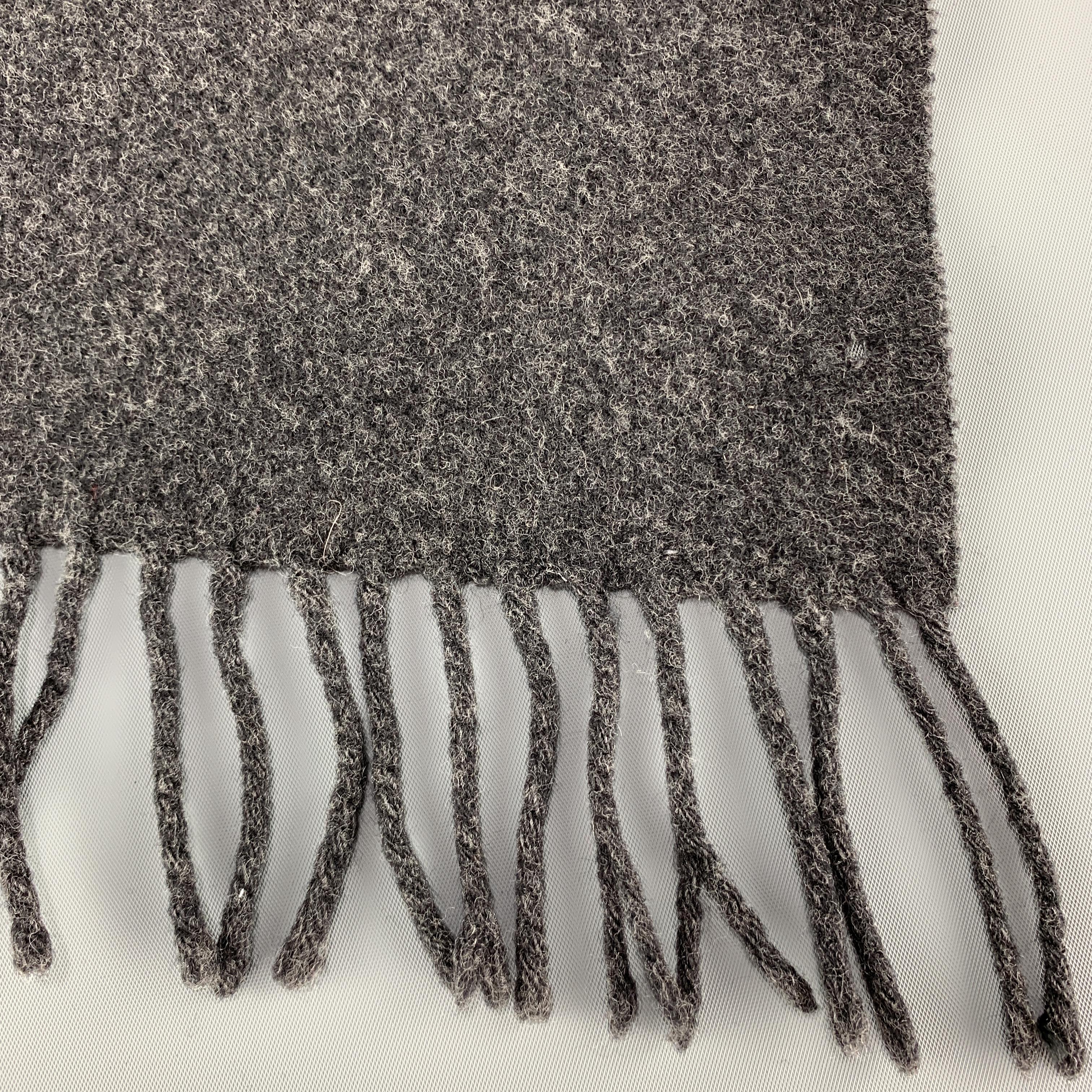 DOLCE & GABBANA scarf comes in heathered charcoal gray wool felt with fringe trim. Made in Italy.

Very Good Pre-Owned Condition.
58 x 12 in.