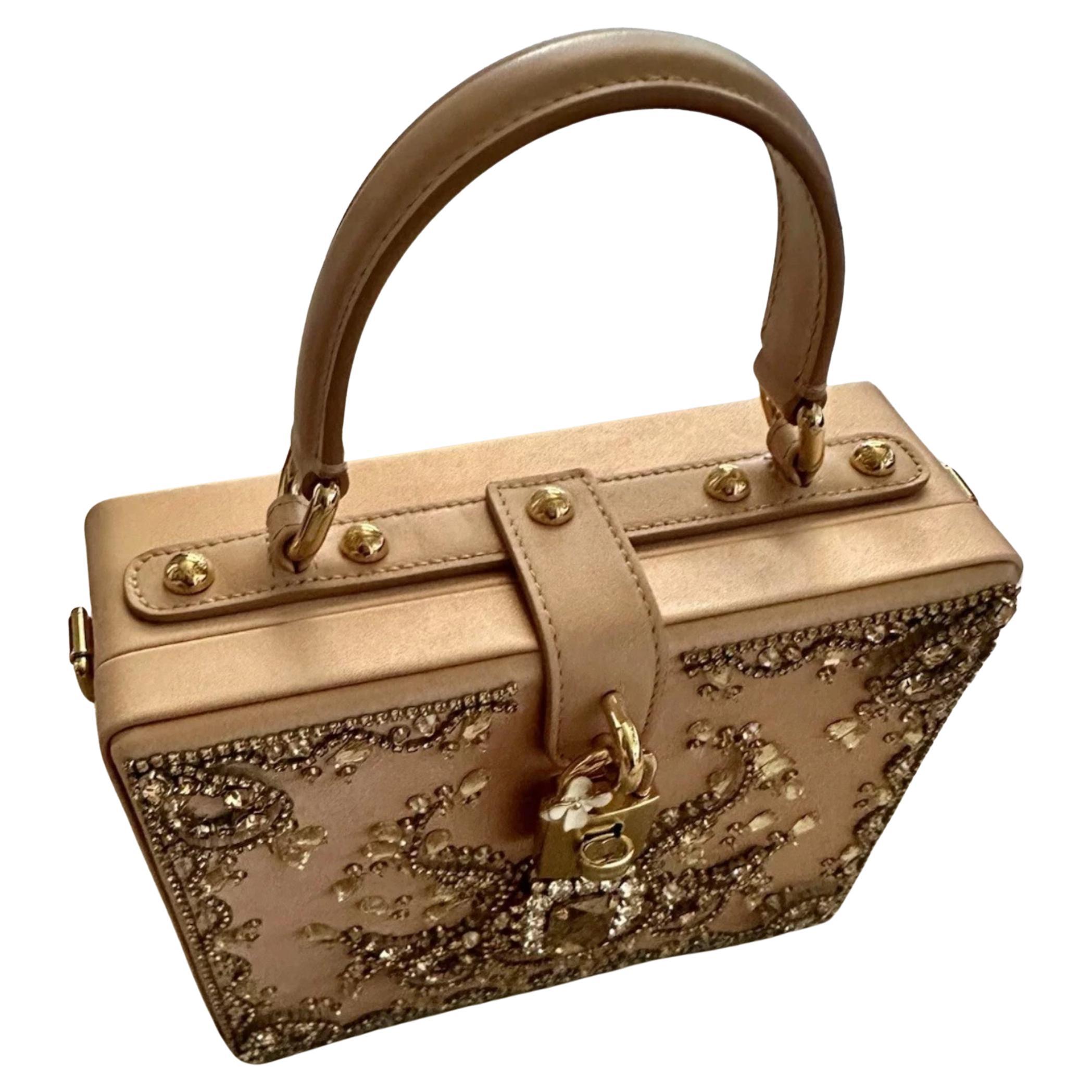 Pièce de collection de Dolce & Gabbana, le très convoité sac Dolce Box est un chef-d'œuvre de l'artisanat italien. Il est réalisé en satin blush et orné de cristaux scintillants.

• Silhouette de boîte en satin avec ornements en cristal et en