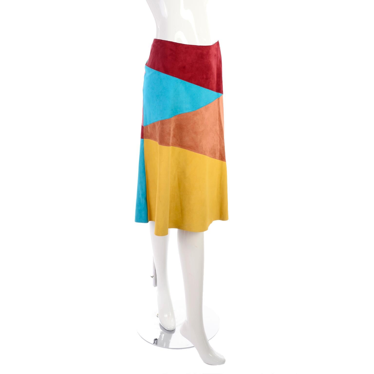 This gorgeous Dolce & Gabbana suede skirt has horizontal triangles of Burgundy, bright blue, brown and yellow gold. We love the contrast of the Fall tones with the aqua blue! Pieces like these are so versatile because they can take you from one