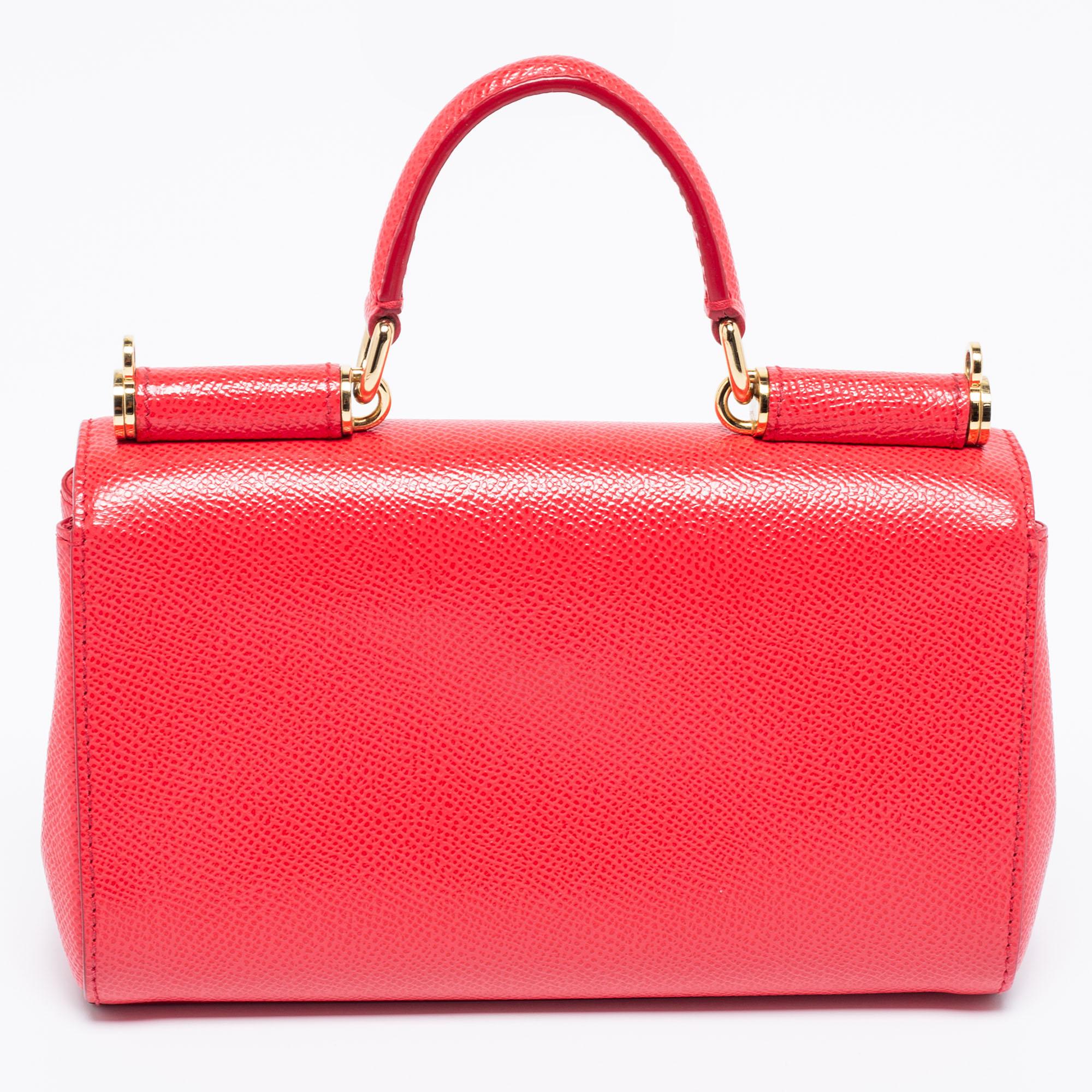 Designed from high-quality leather, this bag has style and durability. A spacious interior lined with fabric promises enough space for your belongings. The Dolce & Gabbana bag in coral pink has a crossbody strap, a top handle, and a front flap. Add
