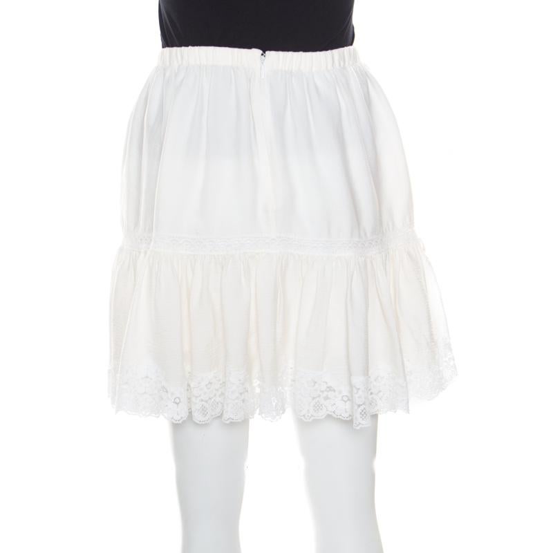 Embrace a carefree style with this skirt from Dolce and Gabbana. It is cut from a blend of crinkled cotton and adorned with lace inserts. This pretty cream skirt comes in a tiered design with a flowy structure. An ideal summer piece, style this up