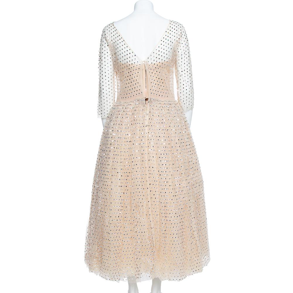 Extravagance meets great tailoring in this breathtaking dress from Dolce & Gabbana. Underpinned with a slip, it has a sheer tulle overlay encrusted with an array of crystals. The gown is fitted around the waistline then flared till the ankles. Match