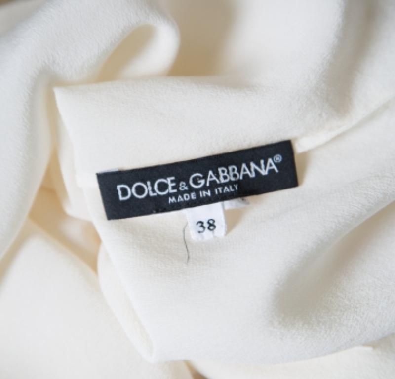 ¡Encontrarás ocasiones para ponerte esta encantadora blusa crema de Dolce & Gabbana! Está confeccionado en una mezcla de seda y crepé, y lleva un detalle de lazo en el escote. Presume de mangas largas con un artístico diseño de apliques de encaje en