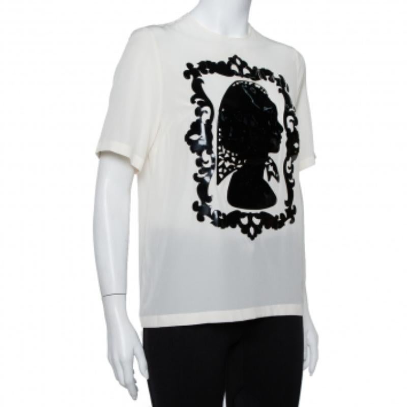 This top from Dolce & Gabbana is effortlessly stylish! The cream creation is made of 100% silk and features an eye-catching applique detailing on the front. It comes with a round neckline, short sleeves, and button fastenings at the back. It will