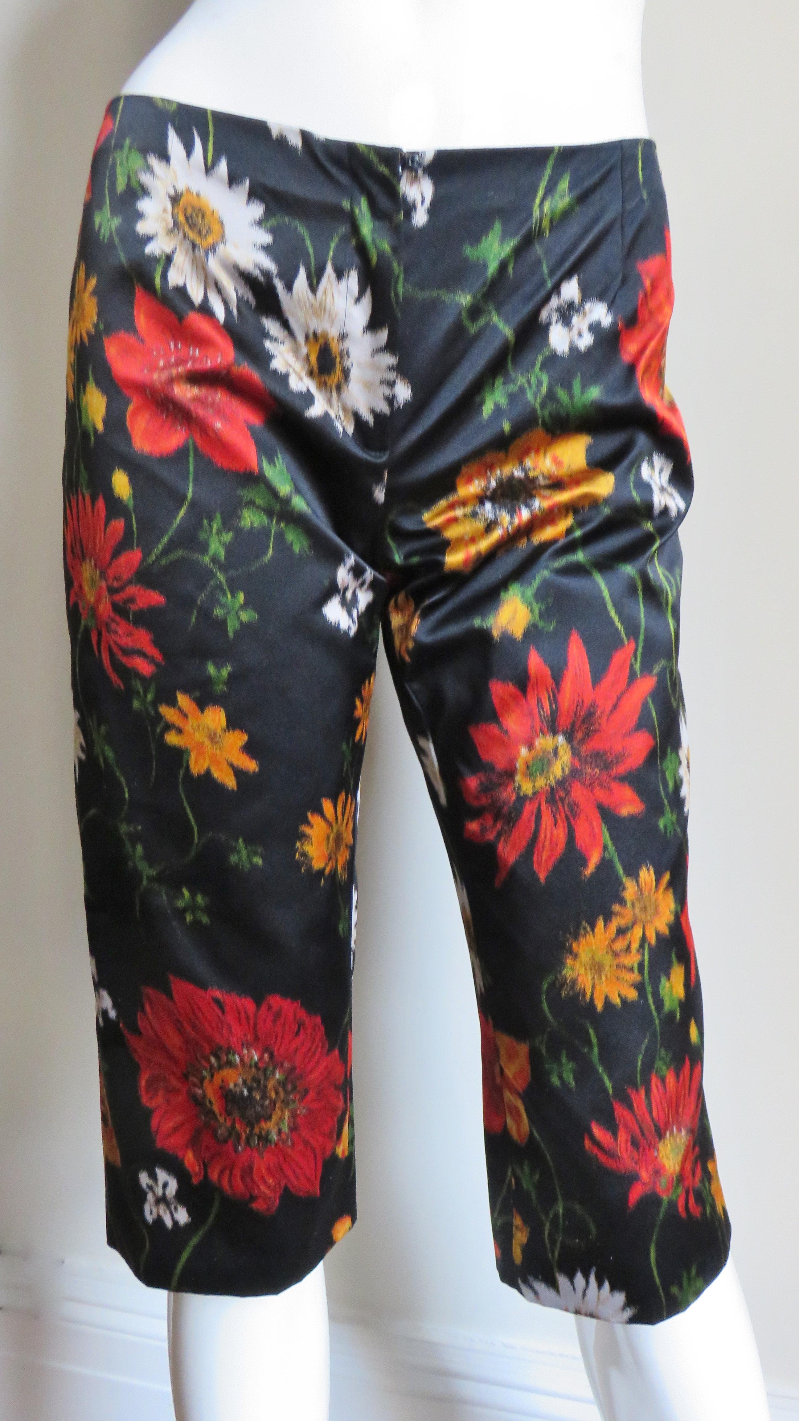 A beautiful pair of silk flowered shorts in red, gold, yellow and green on a black background from Dolce & Gabbana. They are mid rise with a fly front zipper closing, below the knee in length and lined in leopard print silk.
Fits sizes Extra Small,