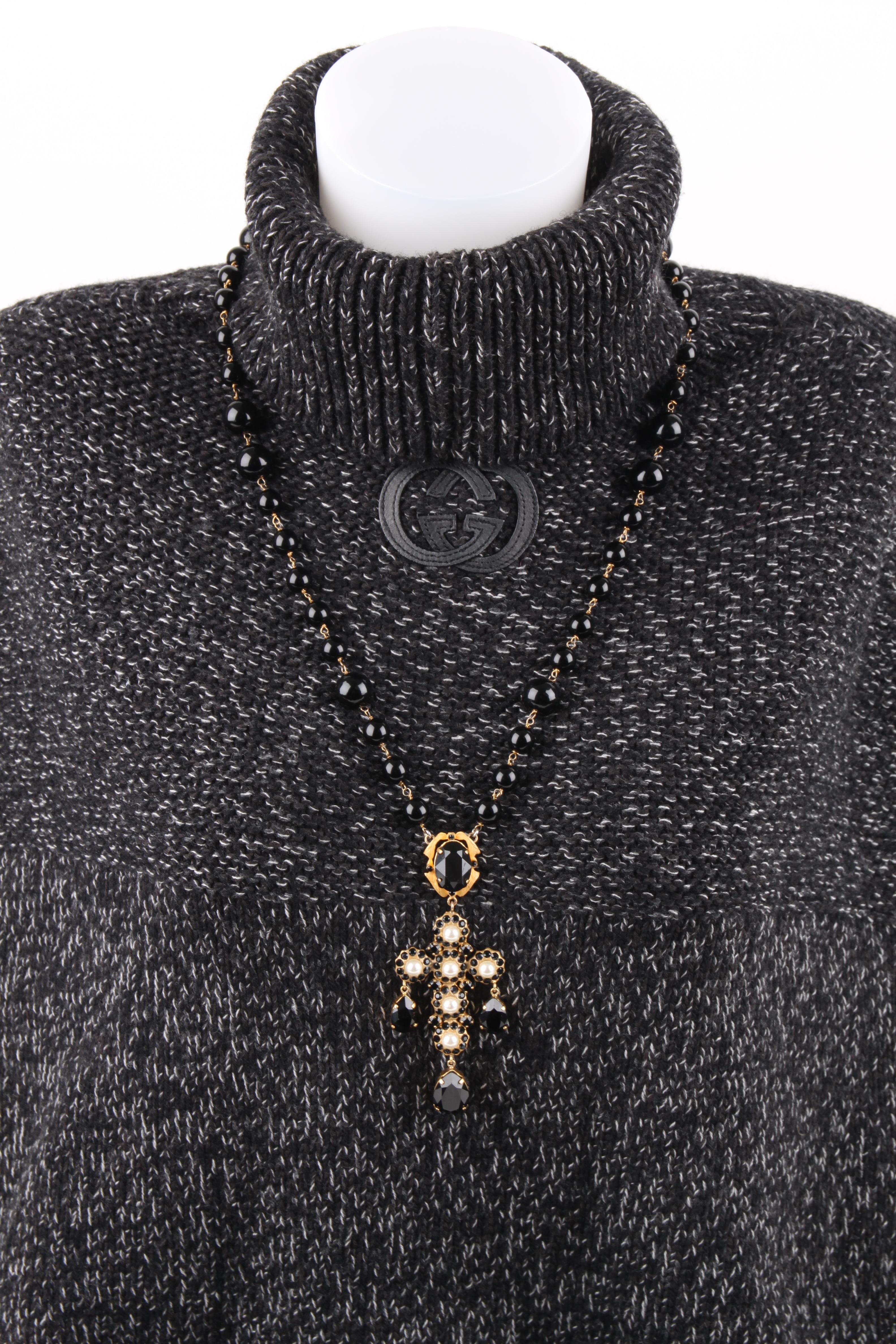 A wonderful long necklace by Dolce & Gabbana, we love the baroque feel!

The black beaded chain is 72 centimeters long, beads have different sizes. In the center a large gold-tone cross embellished with small black crystals and faux pearls.

The