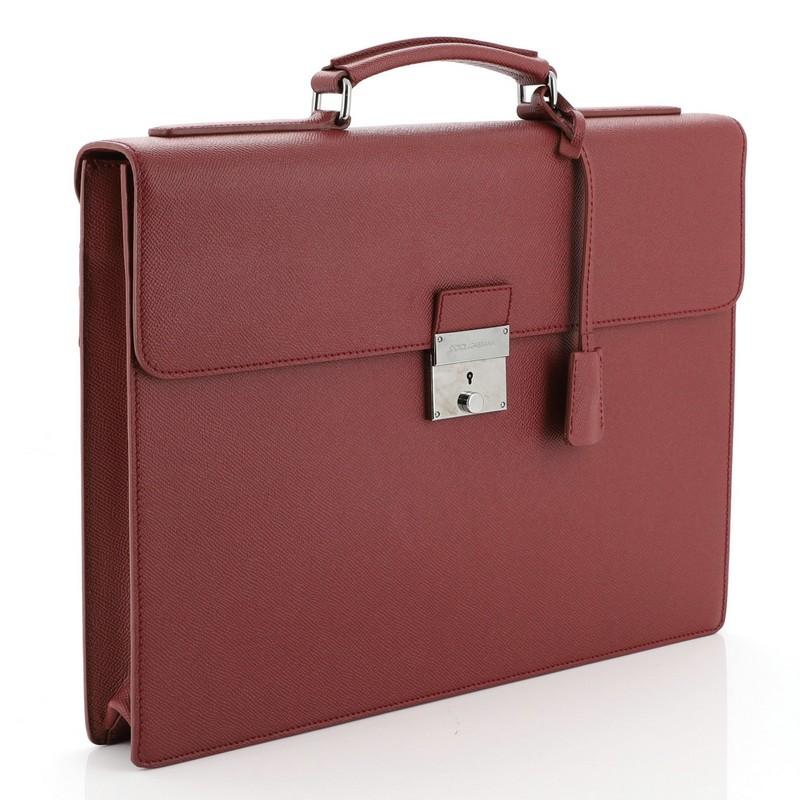 This Dolce & Gabbana Dauphine Briefcase Leather, crafted in red leather, features a leather top handle, foldover top with push-lock closure, exterior back pocket and gunmetal-tone hardware accents. Its push-lock closure opens to a black fabric