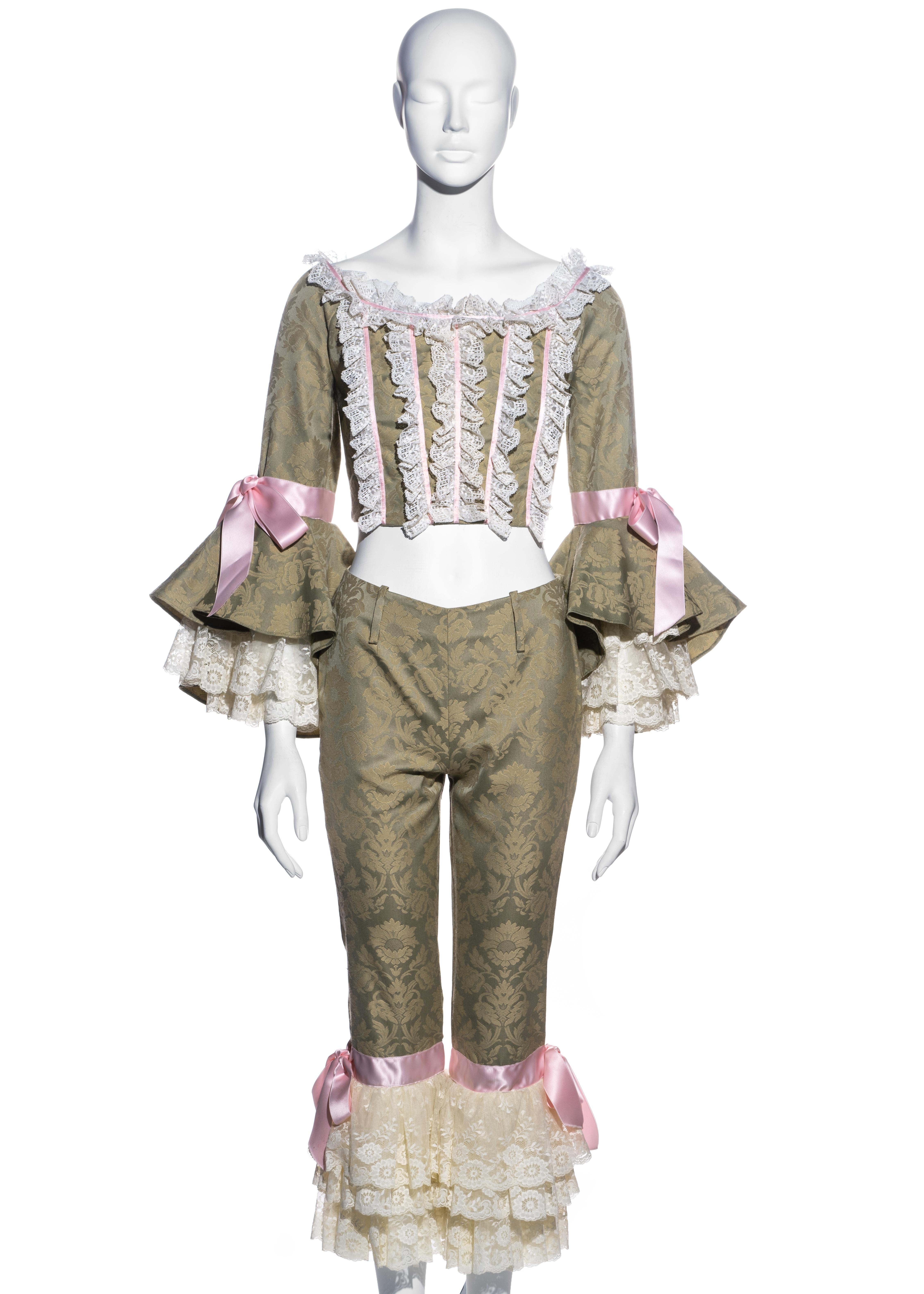 ▪ Dolce & Gabbana (D&G) green brocade corset and pants 
▪ 53% Polyester, 47% Rayon
▪ Cropped corset 
▪ Fitted capri pants 
▪ Bell Sleeves 
▪ Cream lace trim 
▪ Pink satin bow details
▪ Size Small
▪ Spring-Summer 2000