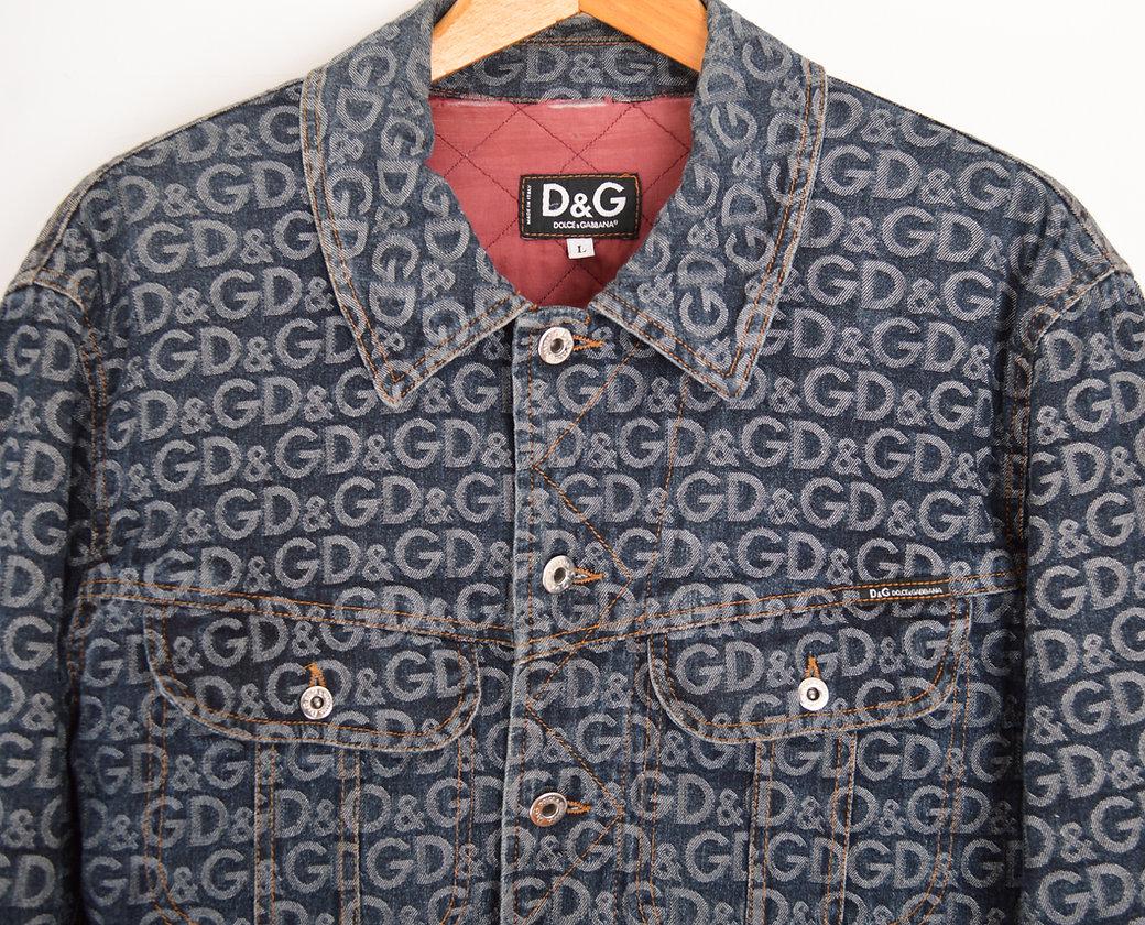 Early 2000's Dolce & Gabbana denim jacket, featuring iconic D&G shredded logo monogram throughout. 
 
Features;
Central line button fasten
Dolce & Gabanna embossed buttons
Chest pockets
D&G breast tab
Burgundy quilted interior lining
100% Cotton