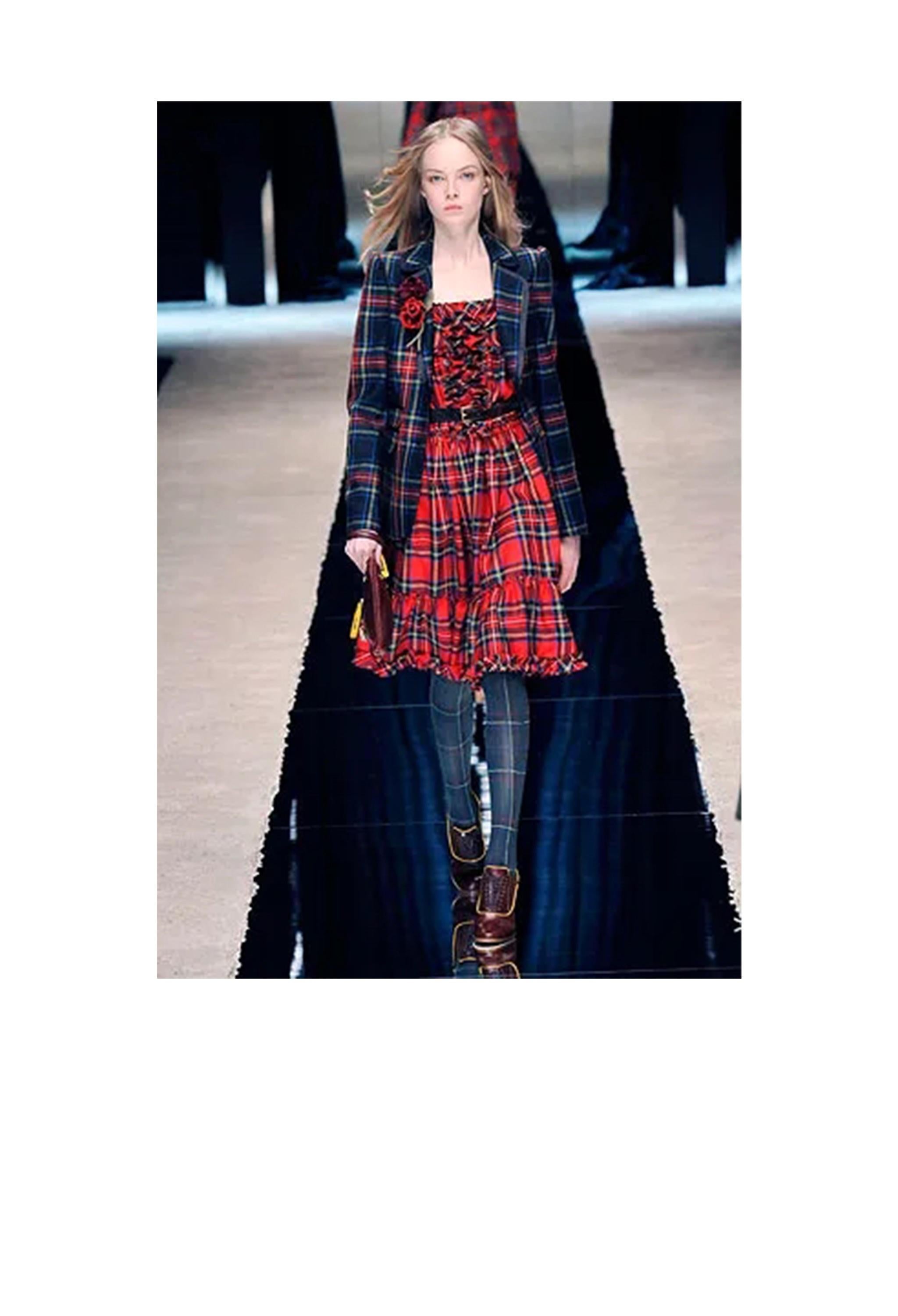 Resurrection Vintage is excited to offer a vintage Dolce & Gabbana D&G wool jacket and skirt ensemble featuring a classic tartan plaid, fitted jacket with black trim, and pleated kilt-style skirt with leather straps and metal buckles.

Dolce &