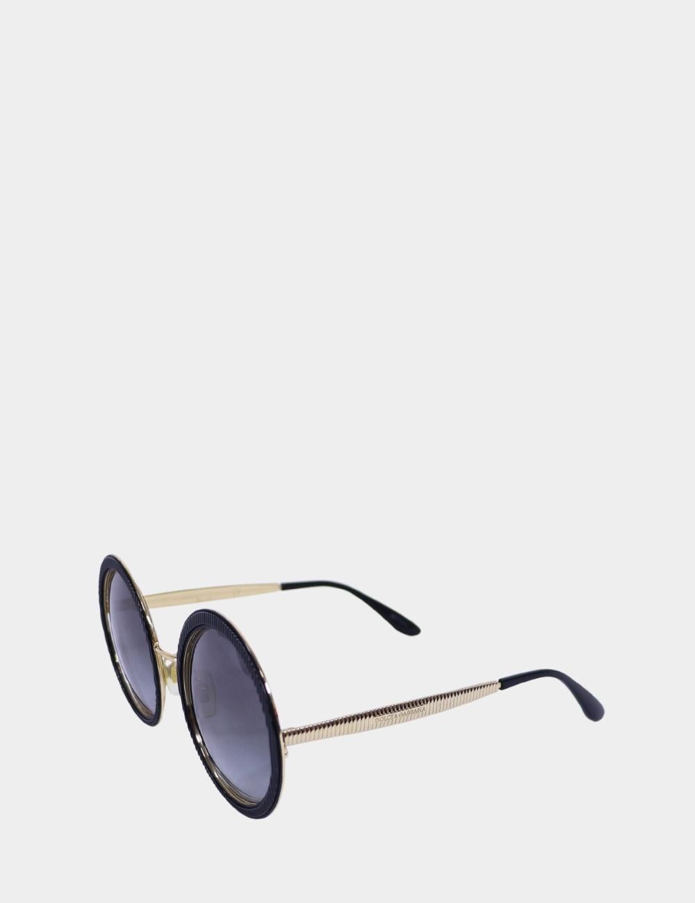 Step into the sun with vintage glamour and Italian flair in these Dolce & Gabbana round sunglasses. Featuring oversized circular lenses framed in black with gold-tone metal arms, these shades balance dramatic style with everyday wearability. The