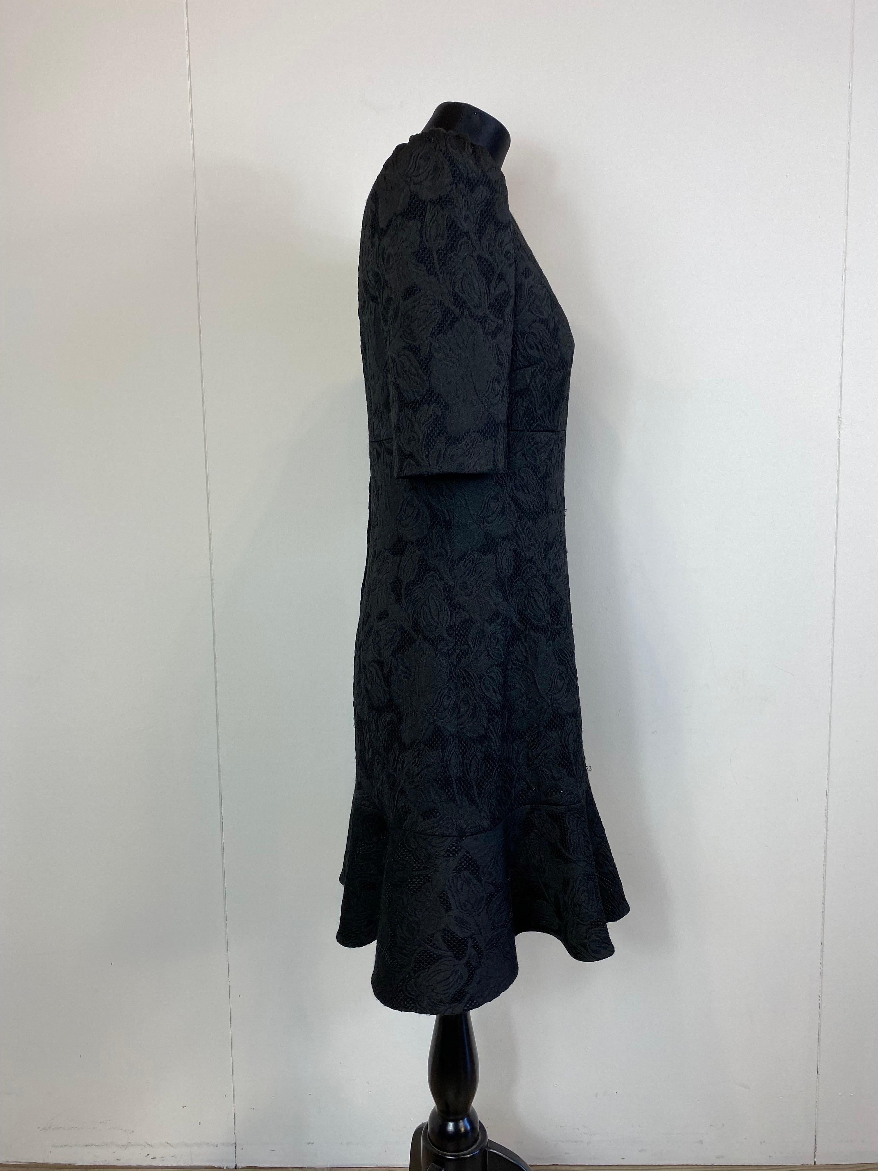 Abito nero di Dolce & Gabbana in broccato di poliestere e viscosa. 
Fodera in seta. 
Chiusura con zip sul retro. 
Mezze maniche a sbuffo. 
Ha alcuni fili tirati ma nel complesso è in ottime condizioni. 
Taglia 46
Spalle 38 cm
Busto 50 cm
Vita 42