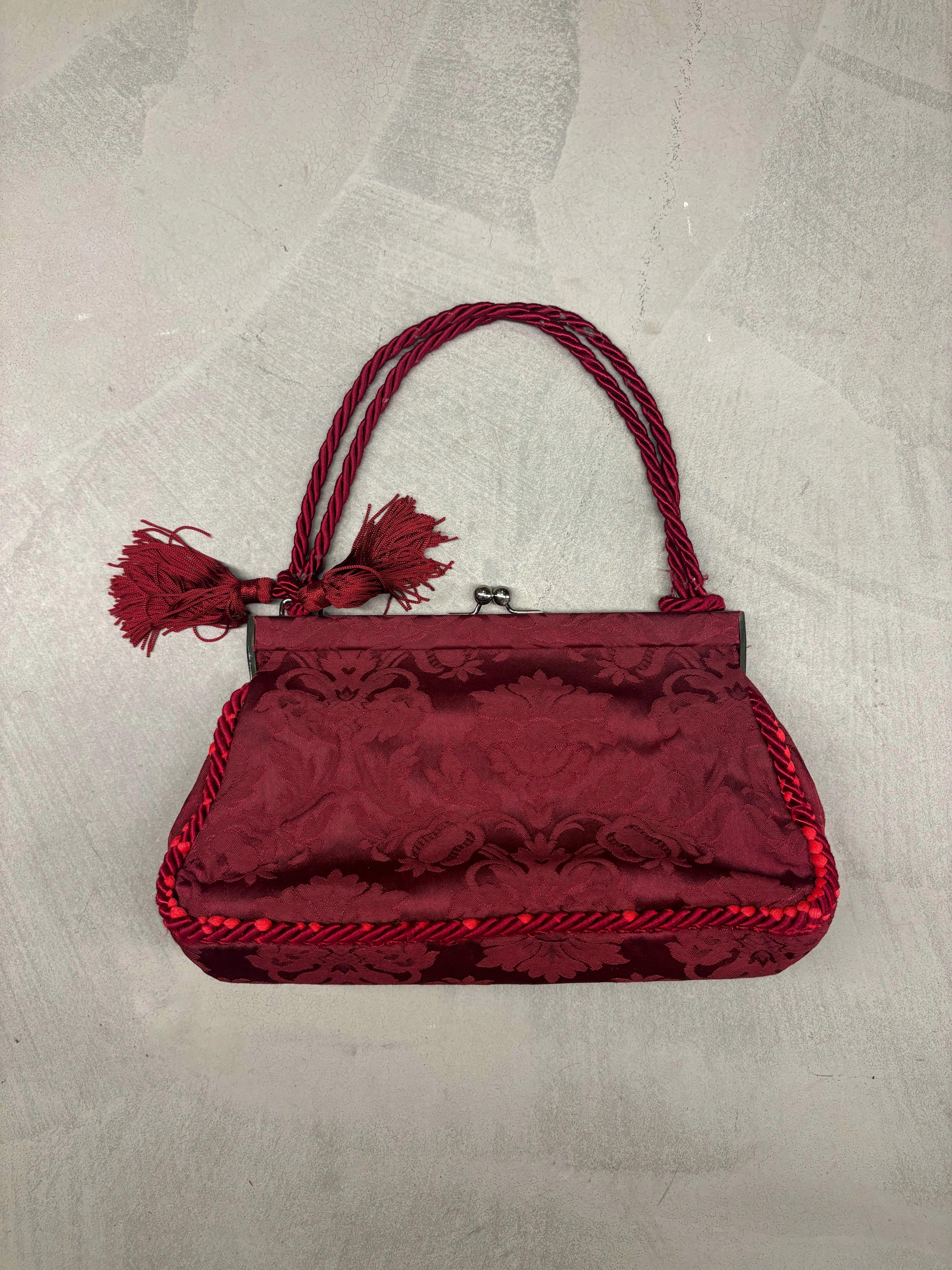 - Dolce & Gabbana 
- Sold by Gold Palms Vintage
- Fall Winter 1997 Collection
- Shoulder bag 
- Clutch closure
- Burgundy brocade print
- Tassels appliqués 
- Twisted cord trim with loose stitching throughout (reflected on price and shown in pics)