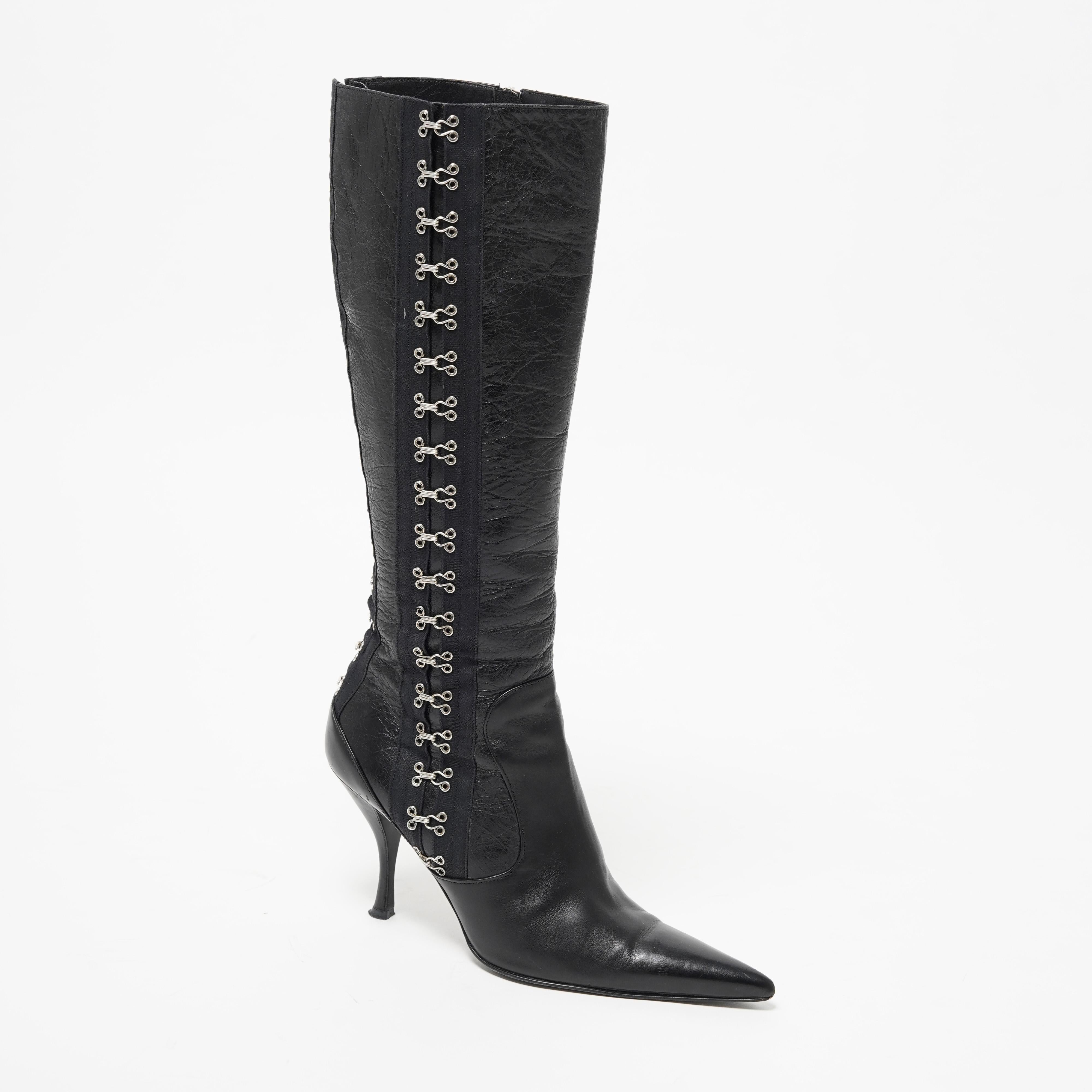 These Dolce & Gabbana knee-high boots from the Fall/Winter 2003 collection are a striking embodiment of the brand’s early 2000s sensuality and craftsmanship. Made from richly textured black leather, they feature a sharply pointed toe and elegant