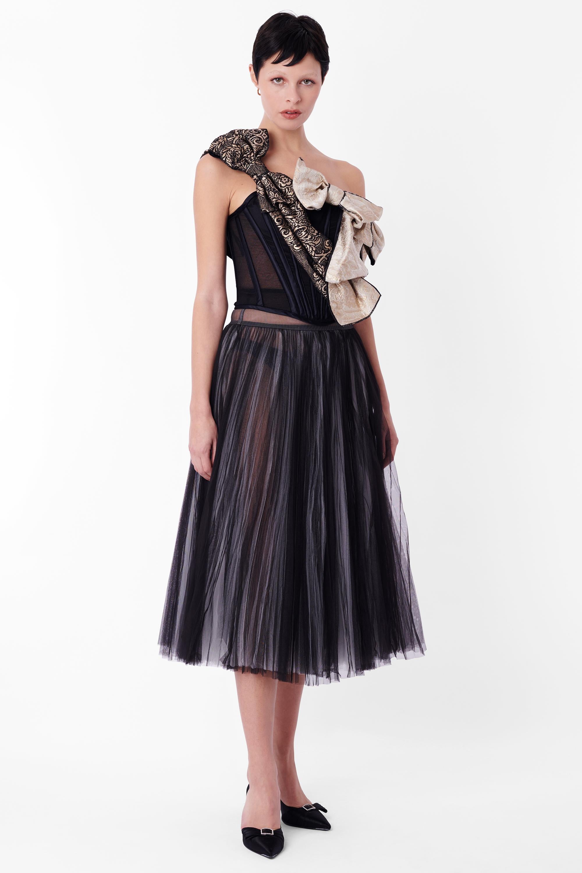 Corsé negro con lazos D&G 2009, como se vio en la pasarela ~ look 5. Presenta un corsé negro deshuesado sin tirantes, 3 lazos de gran tamaño en distintos tejidos y la opción de llevarlo sobre los hombros o sin tirantes, con cierre trasero de