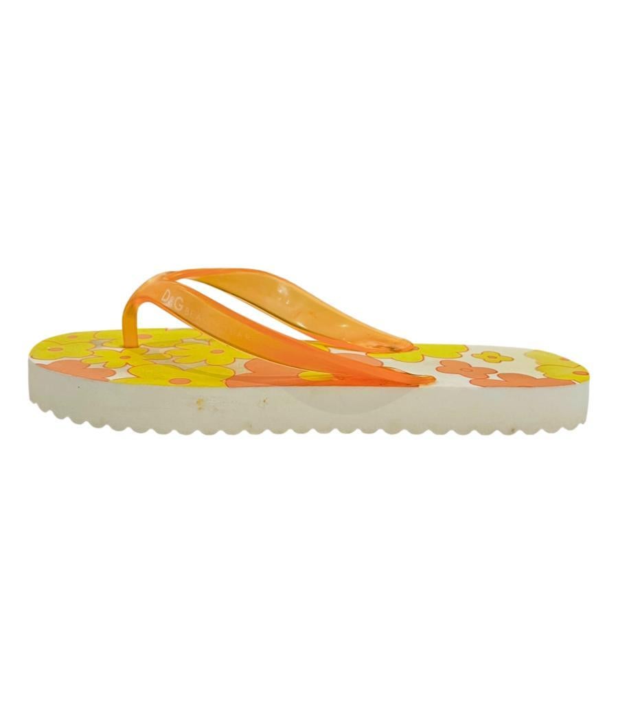Dolce & Gabbana Floral Print Rubber Flip Flop Sandals
White sandals designed with floral prints in yellow and coral.
Detailed with transparent orange thong straps detailed with logo lettering.
Size – L (Length 25.4cm)
Condition – Fair/Good (Visible