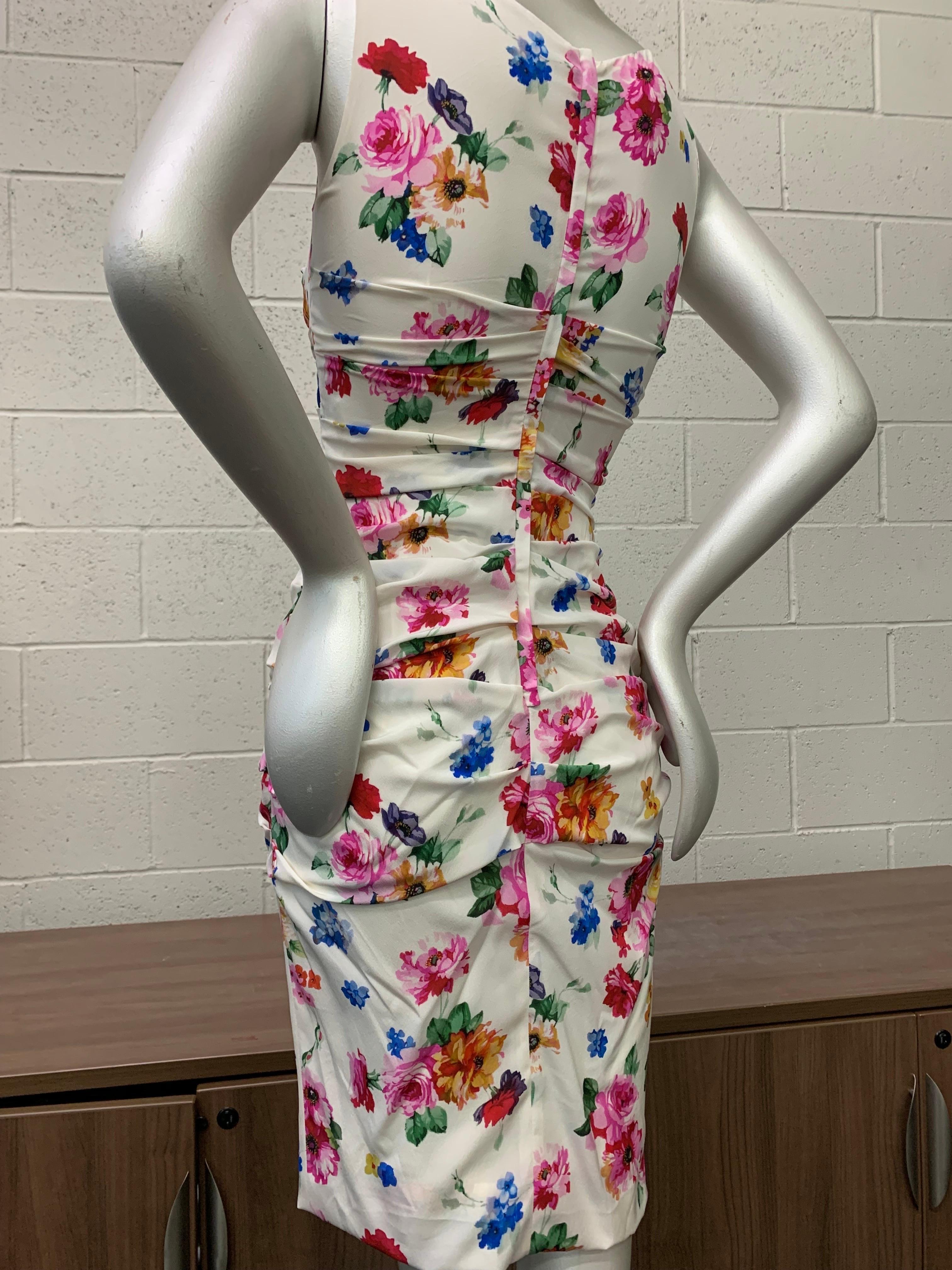 Contemporary Dolce & Gabbana sleeveless stretch silk, floral-print, ruched cocktail sheath in mixed pastels on a white background. Ruching at back of midriff and hips for a great body-conscious fit. New, never worn. Size 42. 