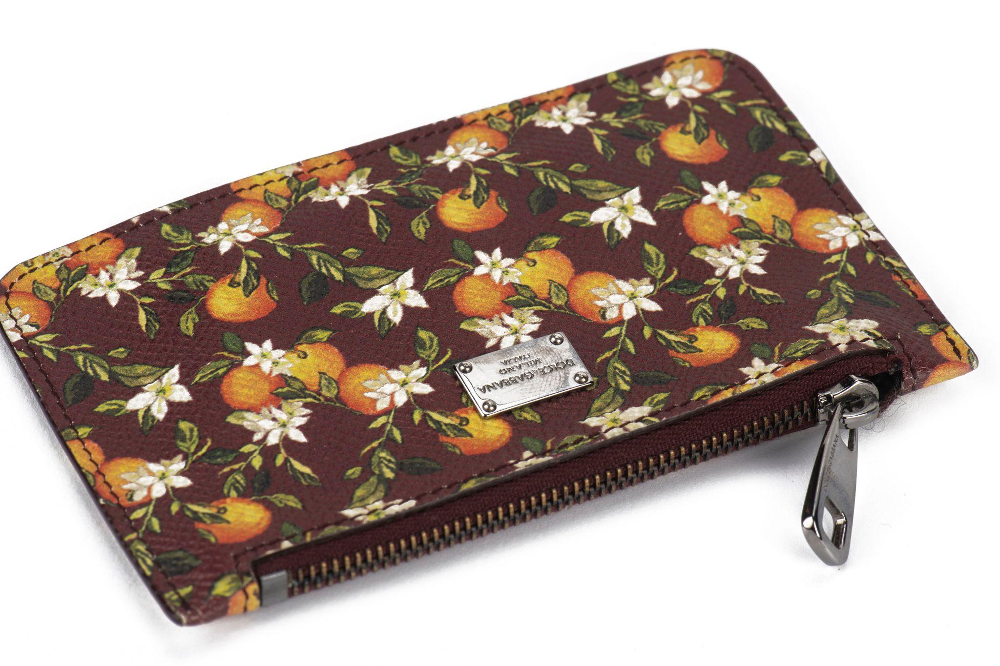 Cartera con cremallera Dolce & Gabbana en burdeos con diseño de azahar. Herrajes de rutenio, llavero interior.