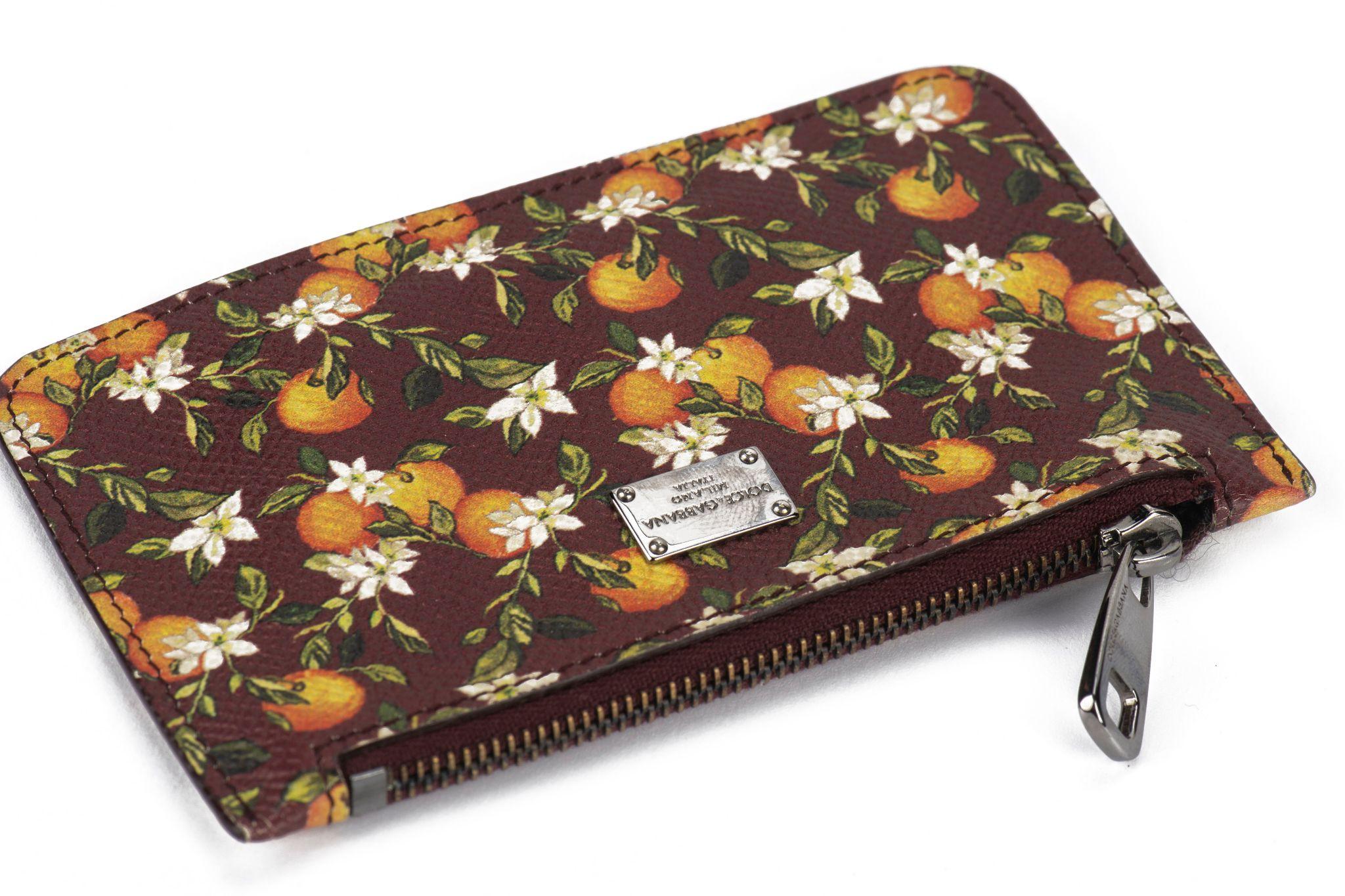 Dolce & Gabbana burgundy zipped wallet with orange blossom design. Ruthenium hardware, interior keychain.