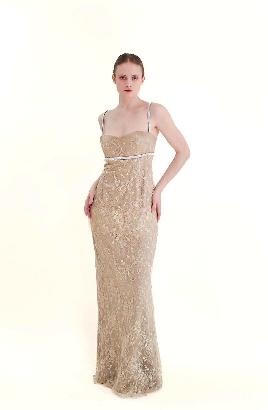 This stunning evening gown by Dolce & Gabbana features intricate gold lace and a rhinestone empire waist, making it the perfect choice for a special occasion. With its sexy yet classy design, it can be worn as an alternative wedding gown or as a