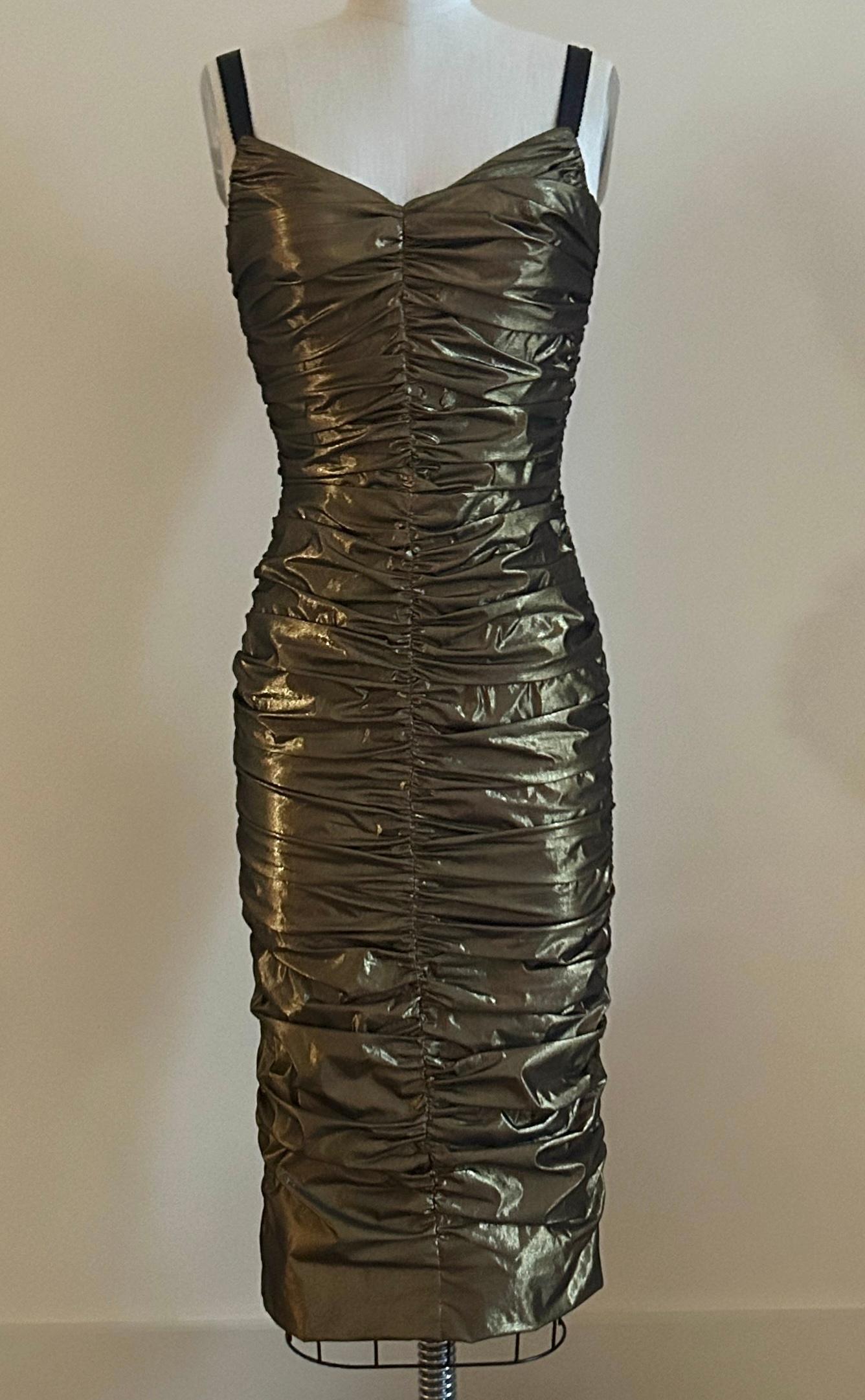 Dolce & Gabbana, abito da cocktail con increspature metalliche in oro bronzato e spalline nere. Chiusura posteriore con zip e gancio.

46% poliammide, 32% poliestere, 12% elastan, 10% seta.

Prodotto in Italia.

Taglia IT 38, approssimativamente US