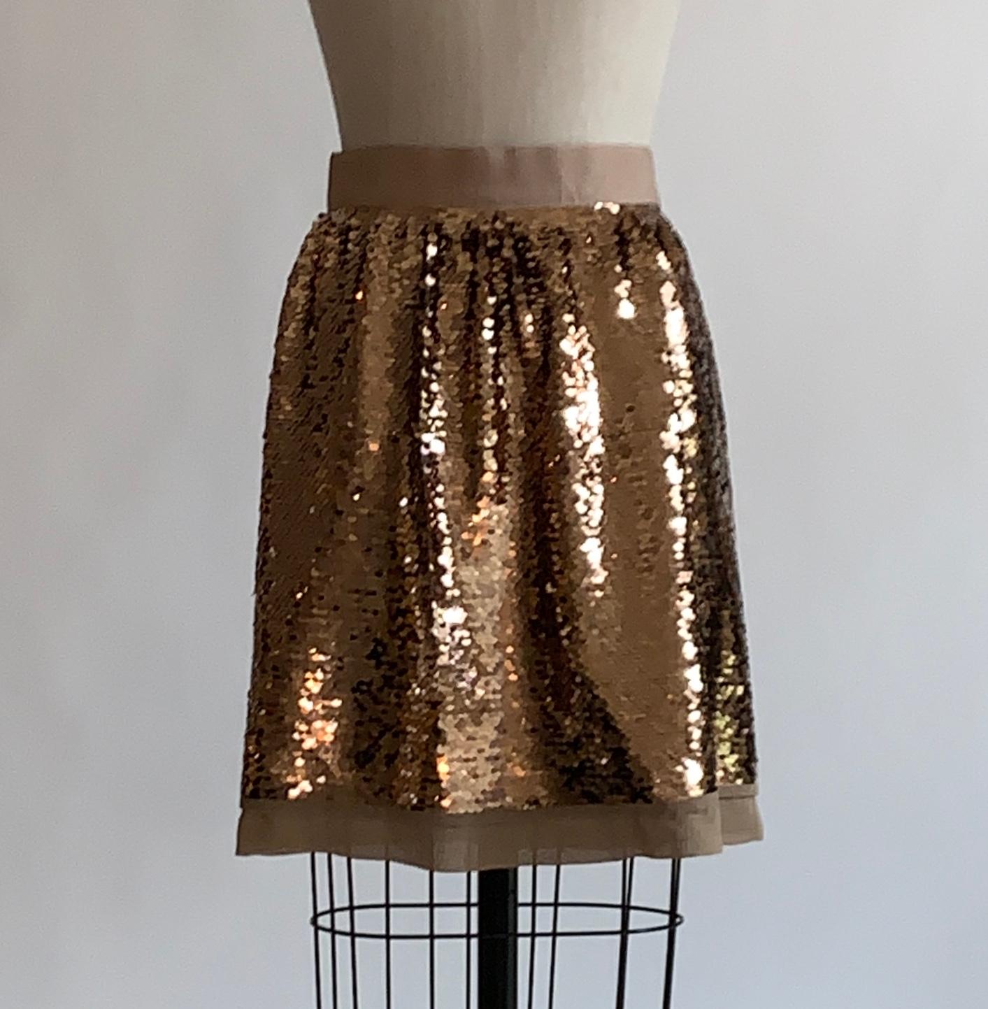Dolce & Gabbana gold sequin skirt with beige silk trim and a grosgrain band at waist. Back zip inscribed with Dolce & Gabbana and  zipper pull with dangling D and G.  

Outer: 100% polyester mesh (covered in sequins.) 
Fully lined in 100% silk. 