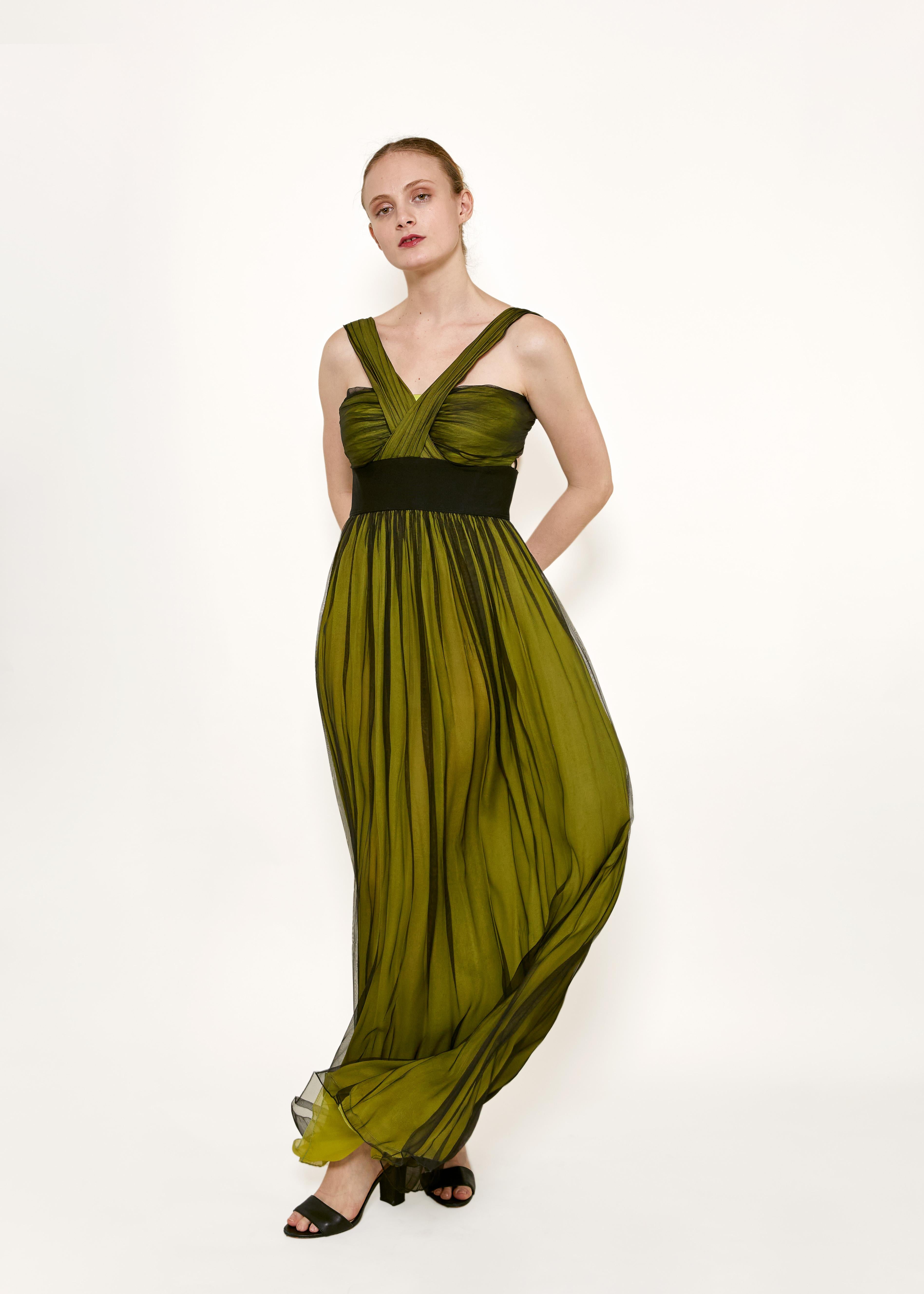 Élevez votre look de soirée avec cette superbe robe en mousseline de soie verte/noire Dolce & Gabbana. Confectionnée en mousseline de soie superposée, cette robe respire le luxe et la sophistication. Le design unique à front croisé ajoute une touche