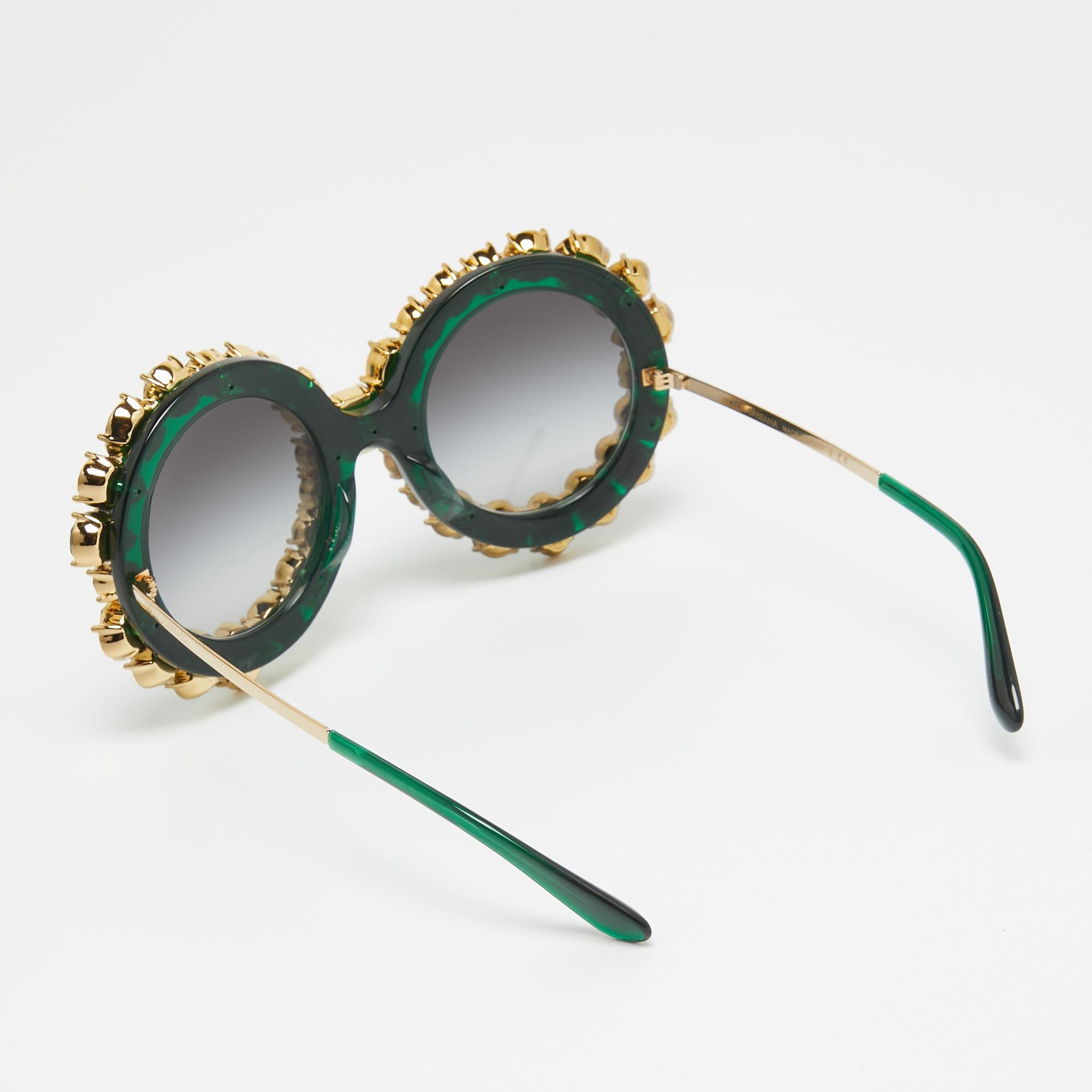 Crafted for the fashion-forward, the Dolce & Gabbana limited edition DG4291 sunglasses exude opulence. Their sleek round frames, adorned with exquisite crystals, radiate elegance. The gradient green lenses offer both style and sun protection, making