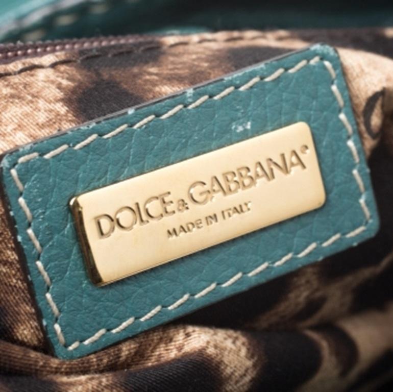 Questo splendido capolavoro è un must-have. Dolce & Gabbana offre uno stile chic con questa borsa Miss Charlotte. Realizzata in Italia, è realizzata in pelle di qualità e in una bella tonalità di verde. È dotata di doppio manico impreziosito da