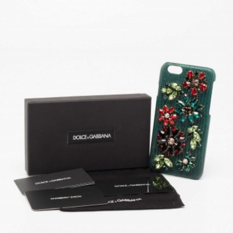 Kleiden Sie Ihr iPhone 6 stilvoll ein und sichern Sie es mit dieser Hülle aus dem Hause Dolce & Gabbana. Dieses mit wunderschönen Kristallverzierungen versehene Etui ist aus grünem, eidechsengeprägtem Leder gefertigt und innen mit Alcantara
