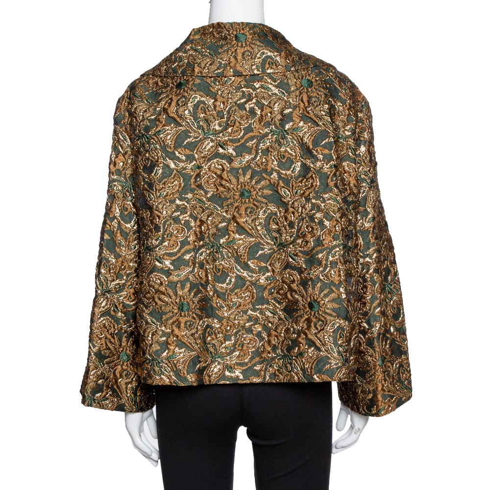 This remarkable jacket from Dolce & Gabbana is a stylish piece to own. It has exaggerated collars and long sleeves. The creation has hues of gold and green which makes it a perfect outfit for evenings. The floral pattern in jacquard gives a royal