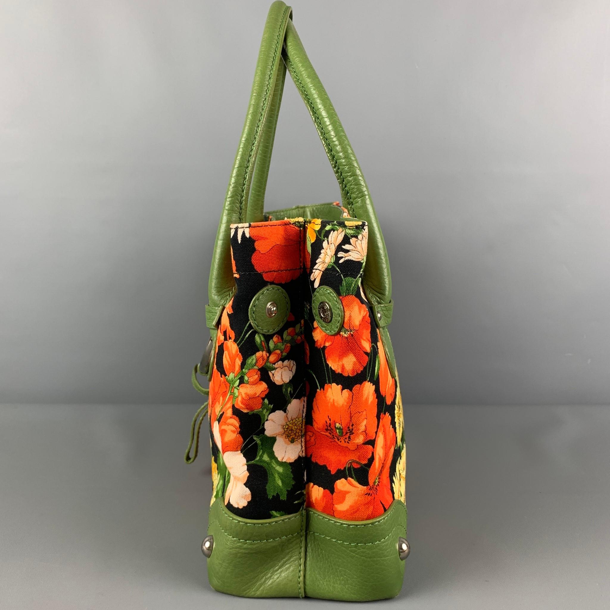 DOLCE & GABBANA handbag comes in a multi-color floral canvas material with a green leather trim featuring a tote style, side buttons, inner pocket, and top handles. Made in Italy. 

Good Pre-Owned Condition. Light wear. As-
