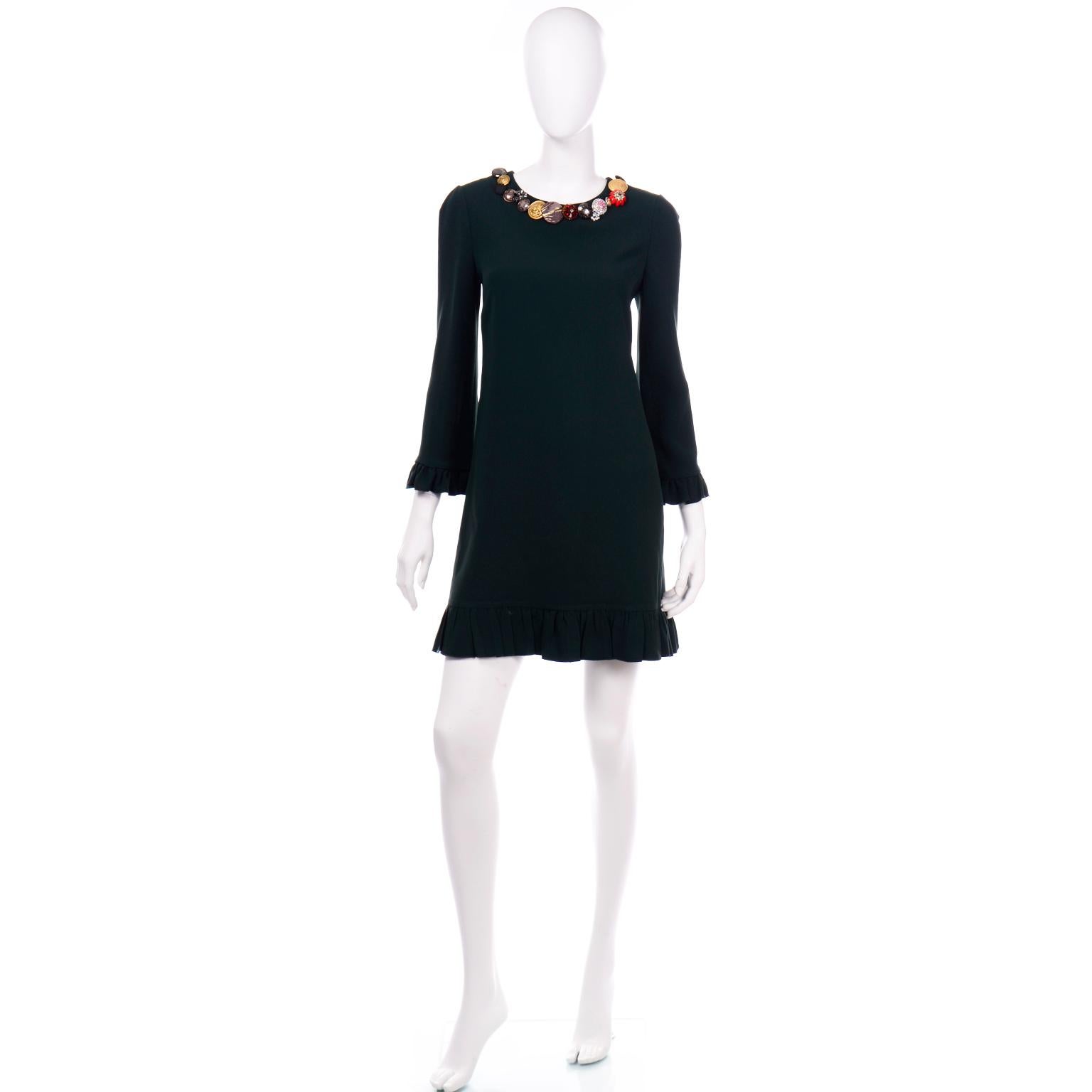This Dolce & Gabbana dress is in a beautiful deep forest green with lovely ruffle trim on the 3/4 length sleeves and the hem. The collar of this dress is why we fell in love with it! It is embellished with assorted buttons (including some Dolce &