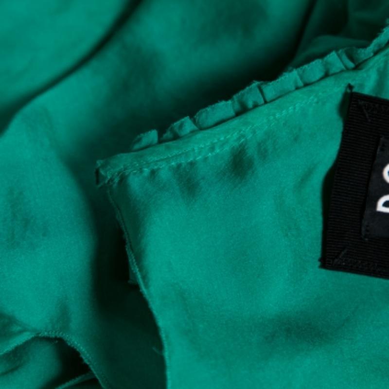 This beautiful top from the House of Dolce & Gabbana is designed for the stylish you! Fashioned in green silk fabric, this top flaunts ruffled formations, an audacious neckline, and a contrasting tie detail on the front. It has narrow shoulder