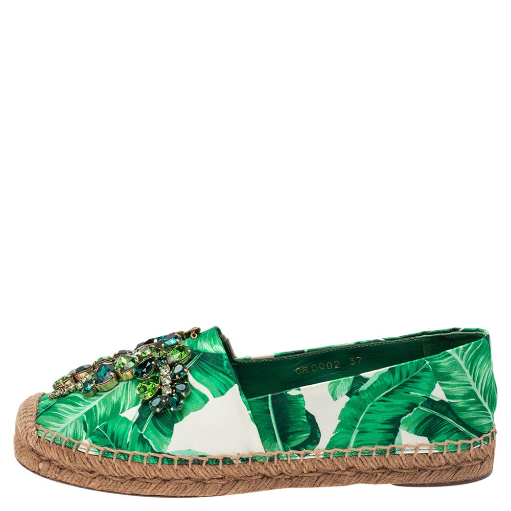 Revamp your footwear collection by adding this pair of Dolce & Gabbana espadrille flats to your wardrobe. The pair is crafted from white & green-hued leaf print satin and features embellishments on the exterior. The flats are complete with