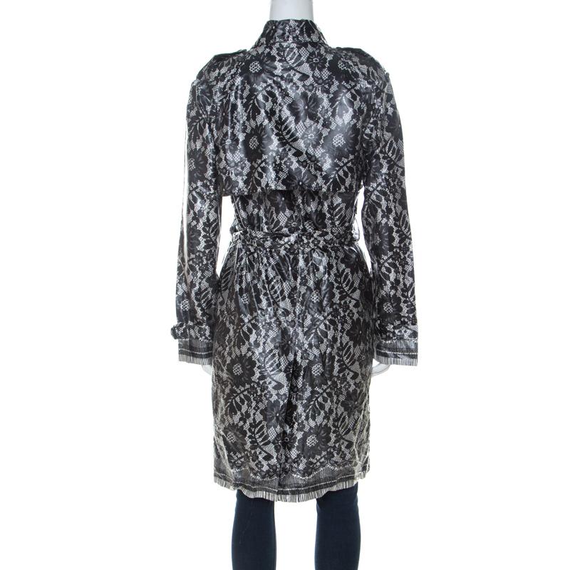 Keep yourself dry and stylish when you wear this Dolce and Gabbana raincoat. Crafted from a coated silk blend, it features a grey hue along with a floral lace pattern all over. It is accented with a tie fastening and button closures. It is