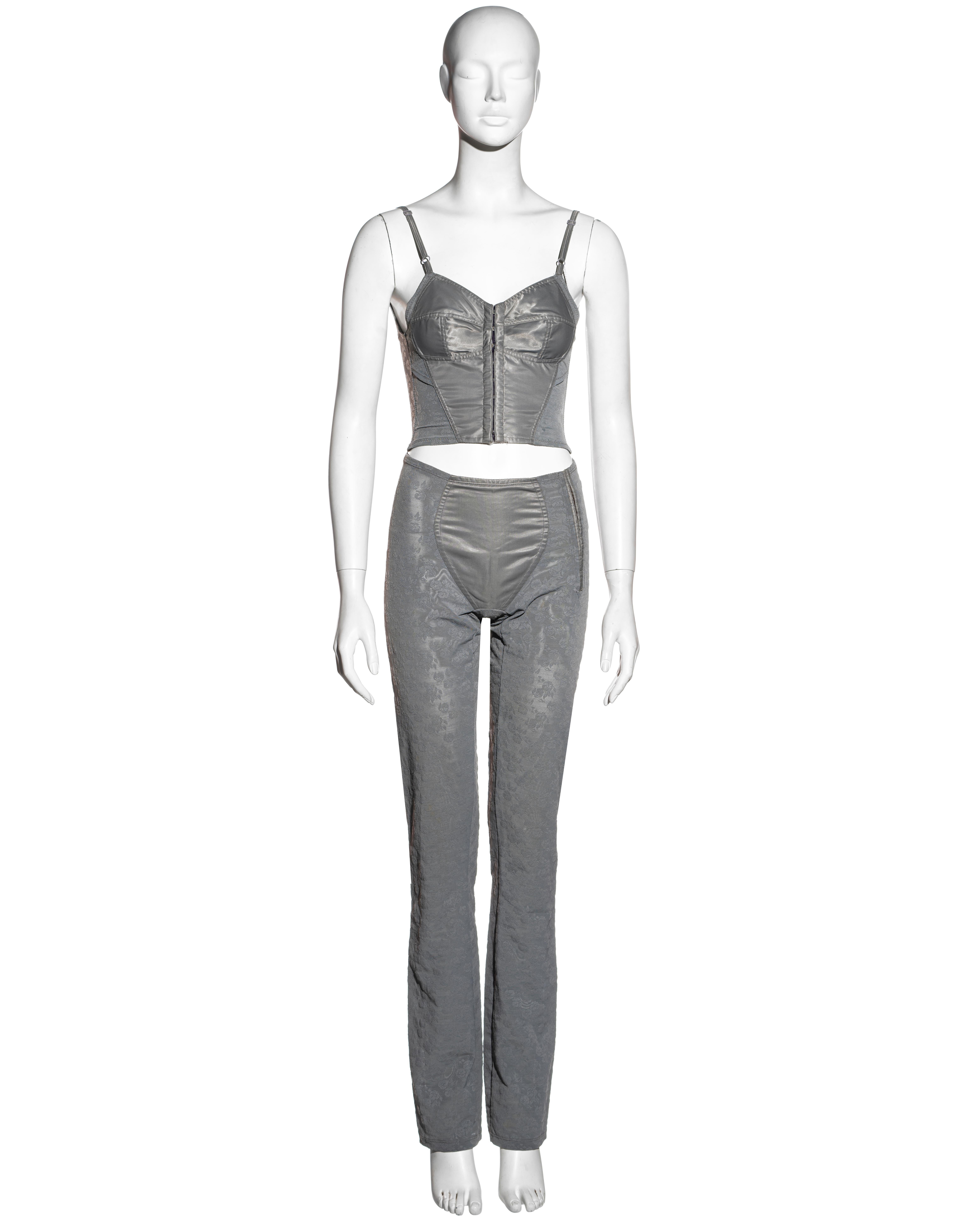 ▪ Dolce & Gabbana grey corset top and pants set
▪ Corset top with center front hooks and adjustable straps
▪ Straight-leg fitted pants with hook fasteners at the hip
▪ Satin panels to the front 
▪ Floral jacquard power mesh
▪ 80% Nylon, 20% Lycra
▪