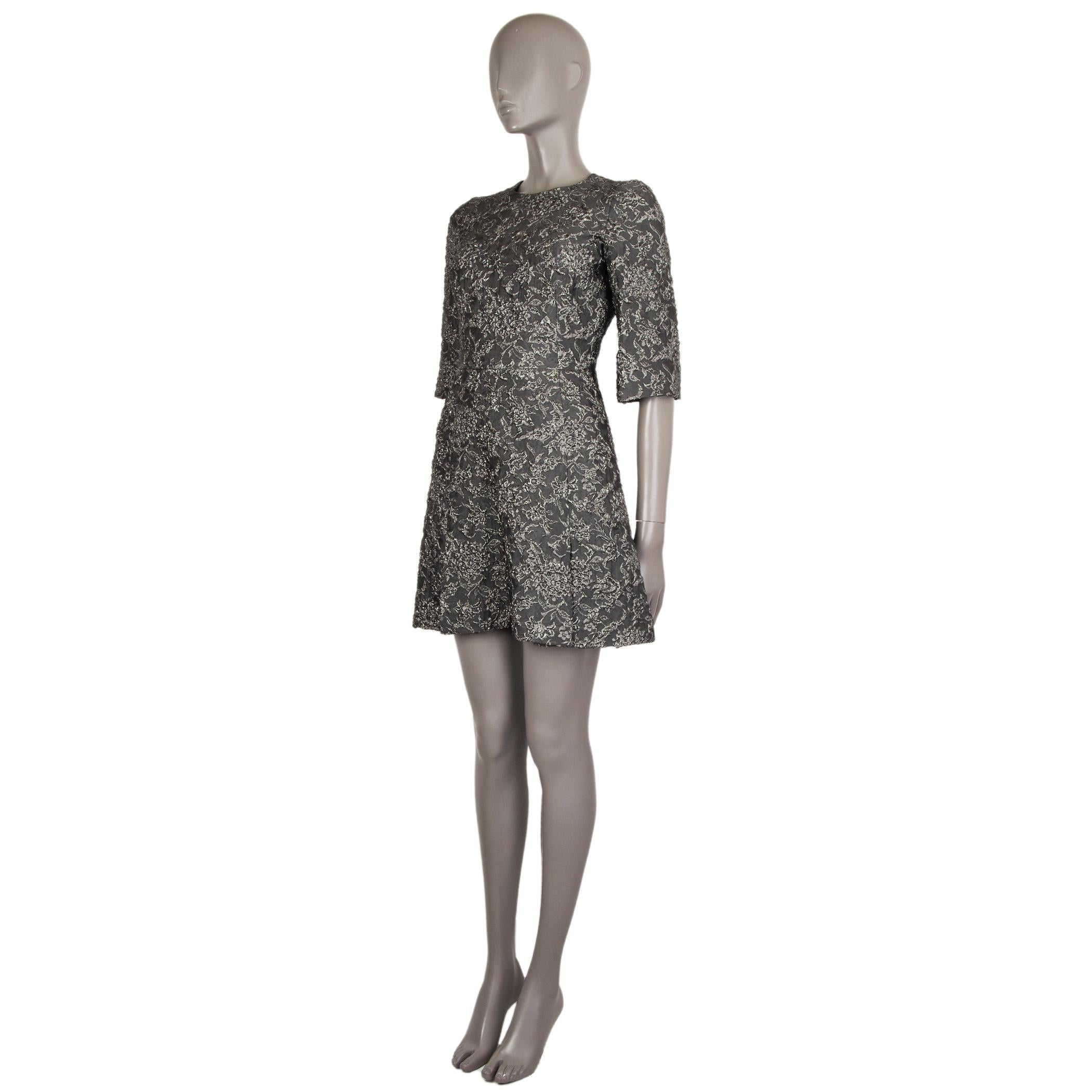 Dolce & Gabbana metallic jacquard 3/4-sleeve dress in grey and silver acetate (38%), nylon (27%), silk (19%), and polyester (18%). With slits around the hemline, Closes with concealed zipper on the back. Lined in grey silk (96%) and elastane (4%).