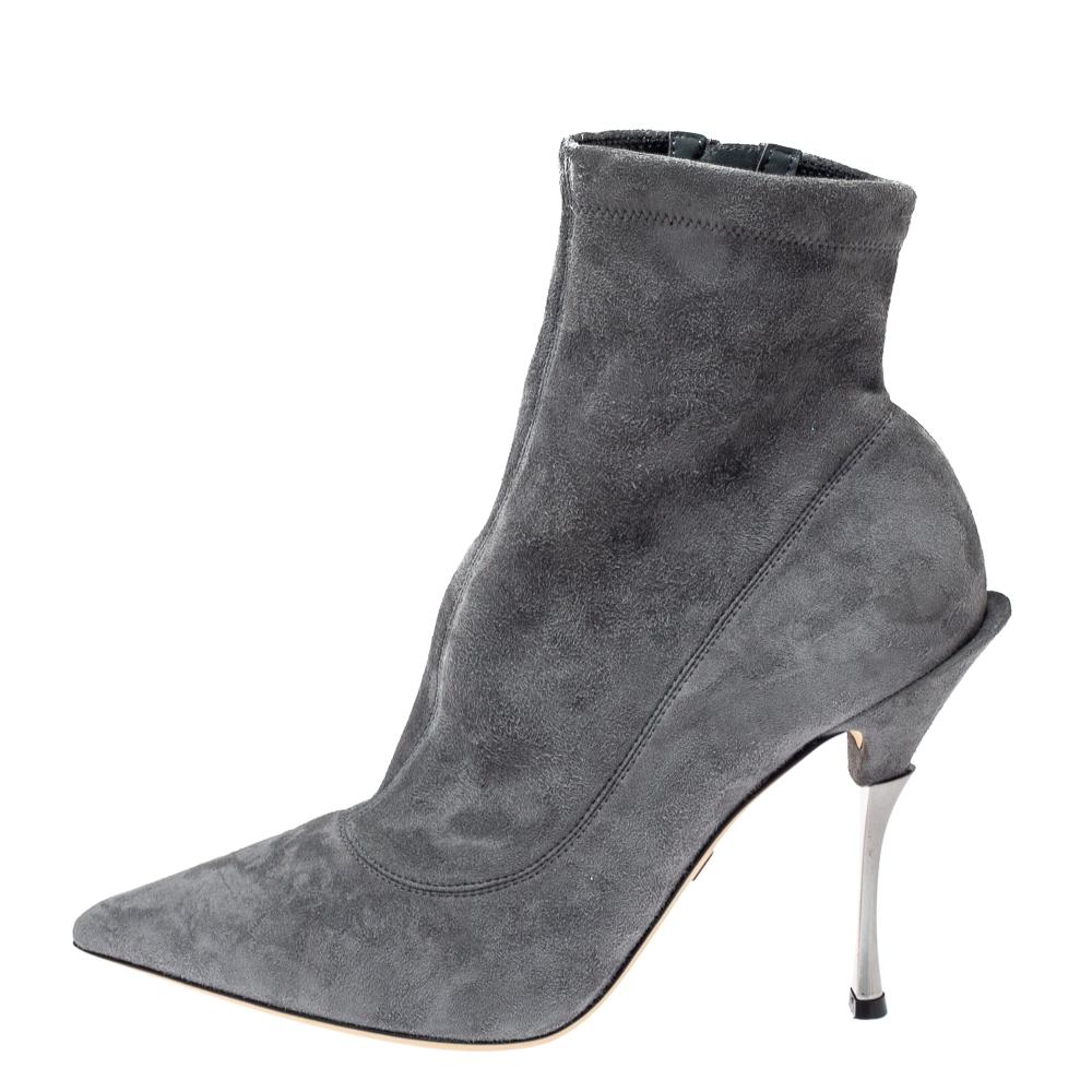 Ponte estos modernos botines Dolce & Gabbana cada vez que salgas para dejar una huella imborrable. Fabricados en ante de color gris, tienen puntera puntiaguda y cierre de cremallera. Estos botines tienen un tacón de 11,5 cm y unas cómodas