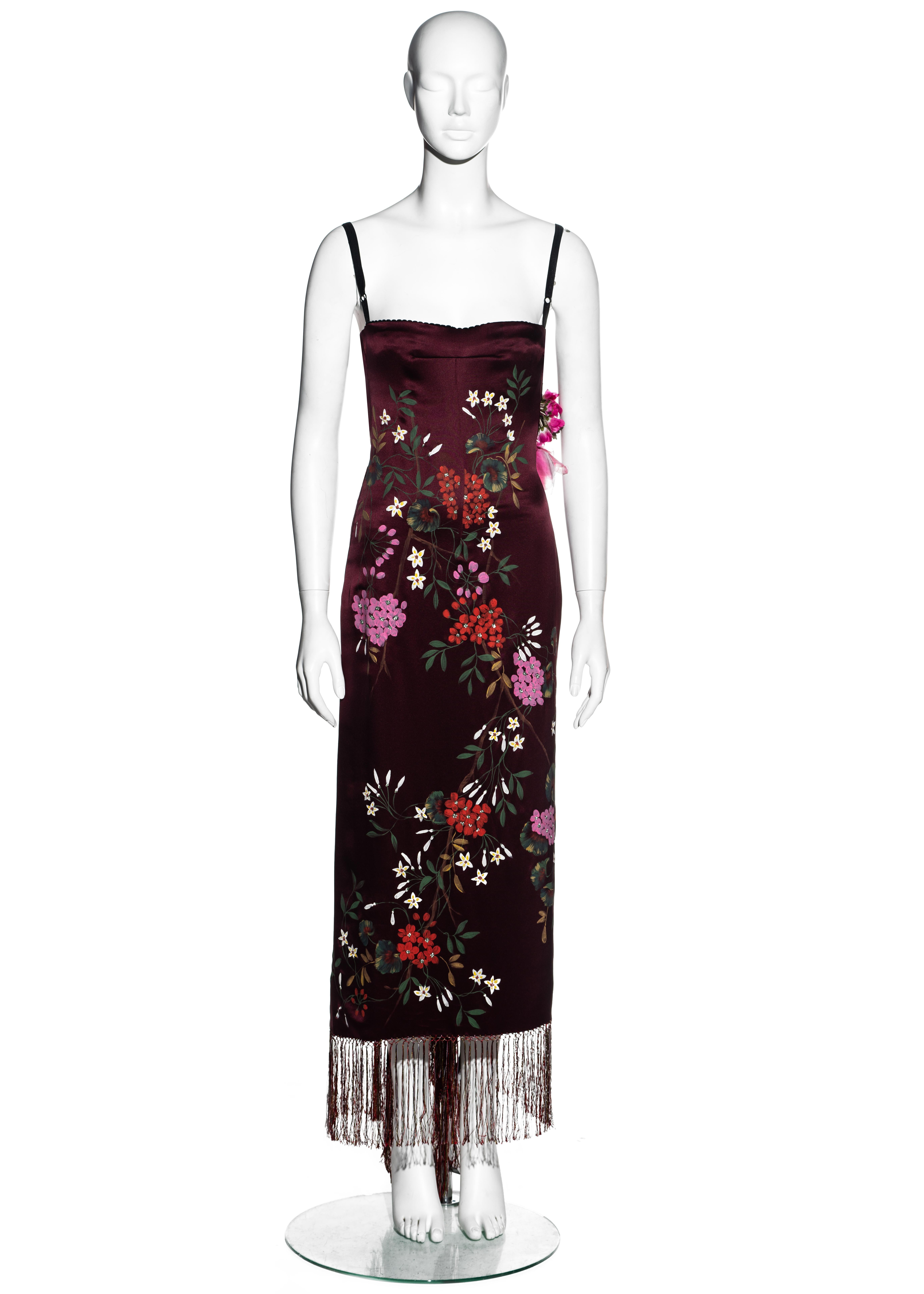 ▪ Dolce & Gabbana burgundy silk evening dress 
▪ Hand painted floral design unique to every piece 
▪ Built in corseted bodysuit 
▪ Organza and velvet floral appliqués applied at the back 
▪ Silk string trim at hem 
▪ Metal hook fastenings 
▪ Couture