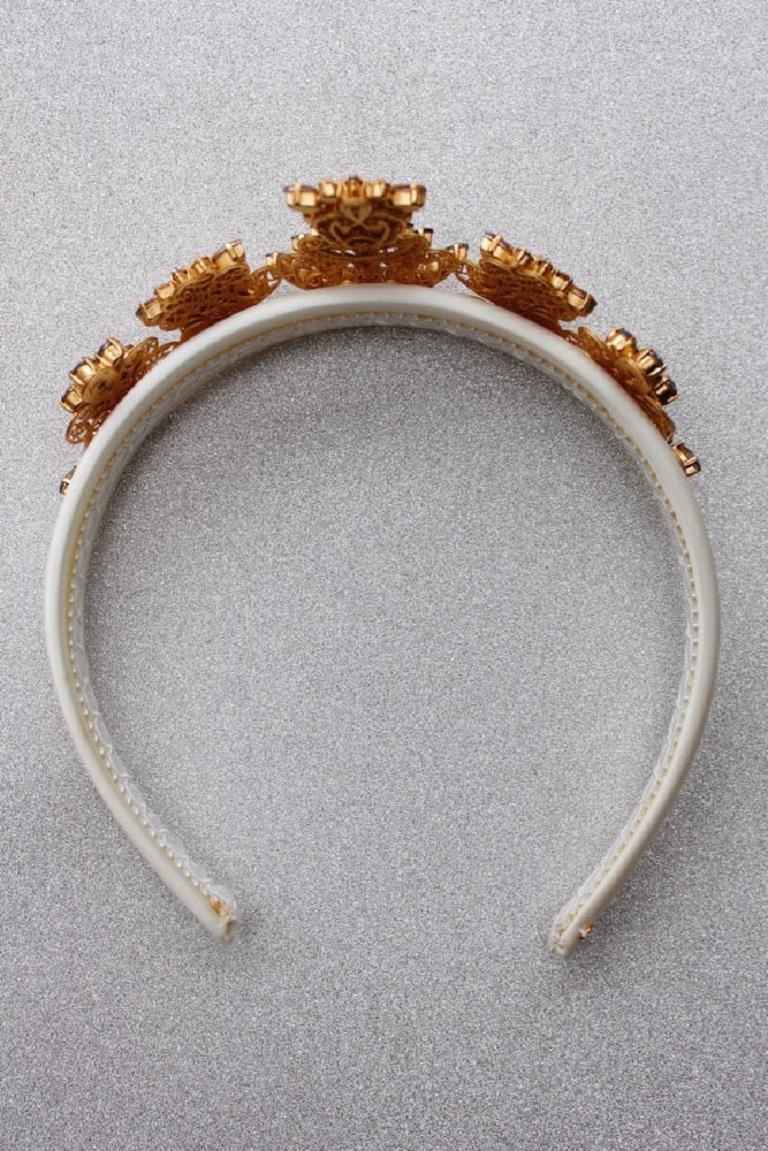 Dolce & Gabbana (Made in Italy) Stirnband/Krone aus weißem Satin, vergoldetem Metall und Strasssteinen.

Zusätzliche Informationen: 
Abmessungen: Länge: 34 cm (13.38 in) - Öffnung: 8 cm (3.15 in) - Maximale Höhe: 5,5 cm (2.16 in)
Zustand: Sehr guter