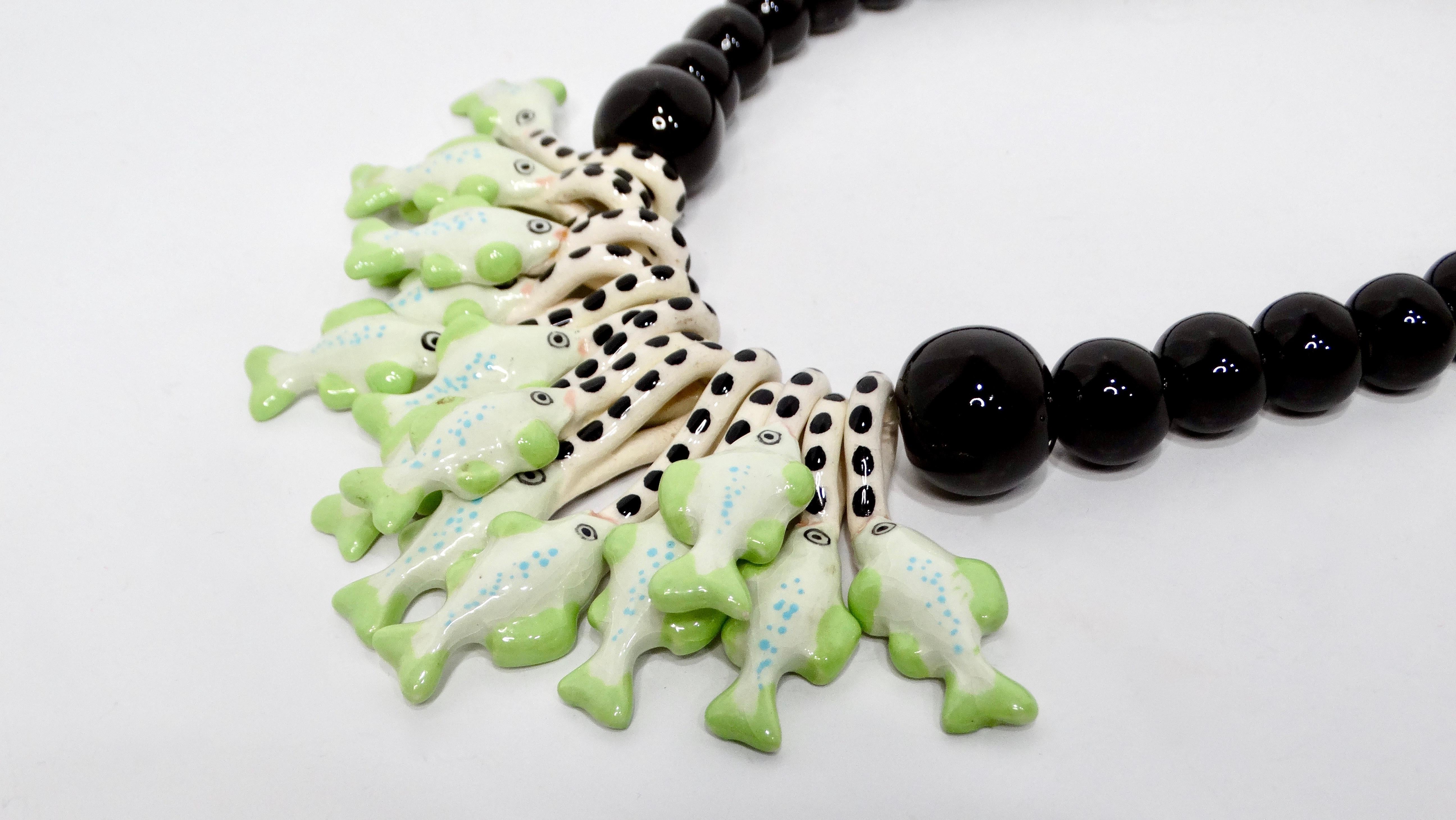 Voici l'envoûtant collier de perles de perroquet et de poisson en céramique inspiré de Dolce & Gabbana, une pièce époustouflante fabriquée en 1976 qui allie magnifiquement une esthétique audacieuse et un design complexe. Le cœur de ce collier est