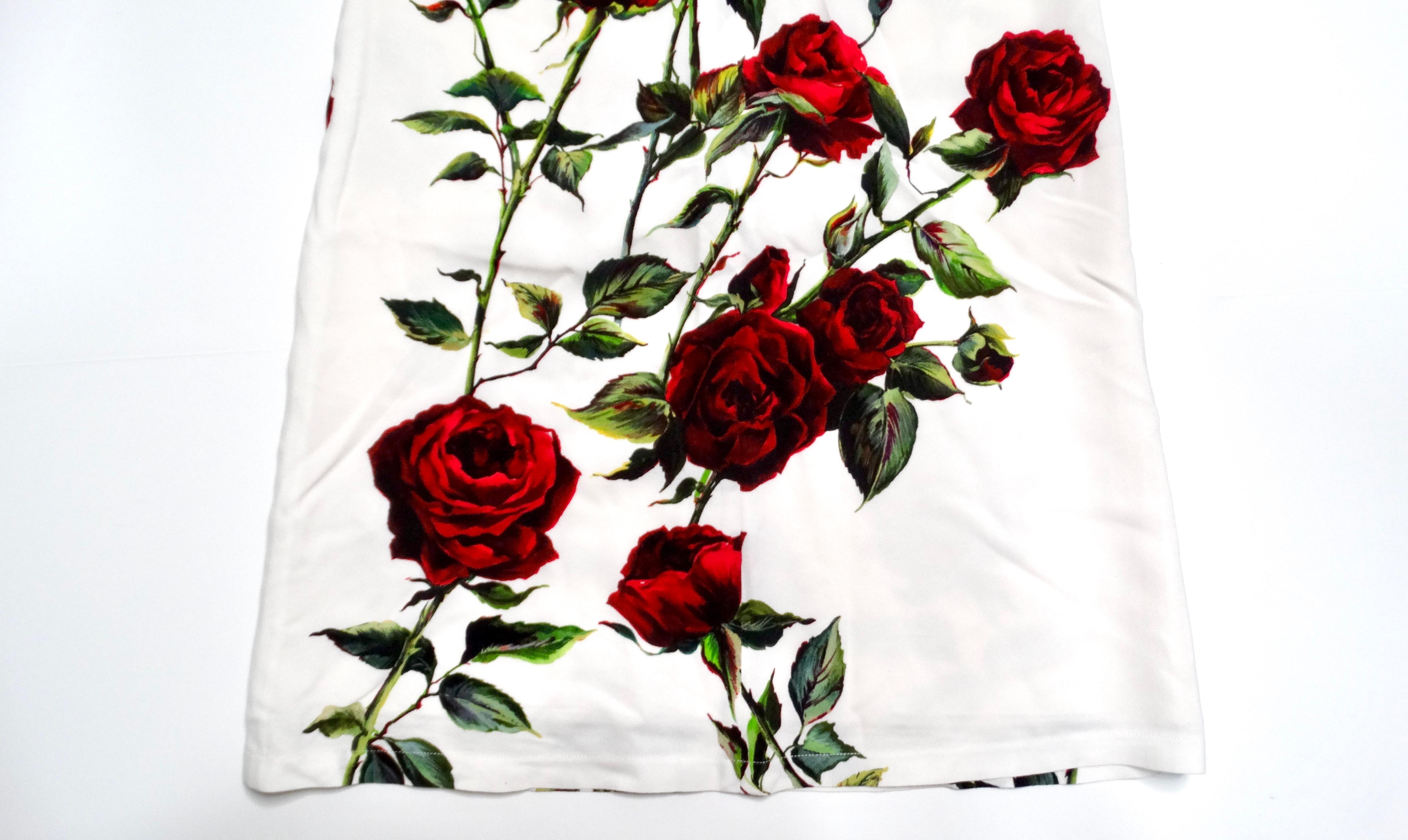 The Dolce & Gabbana Junior Girls Sleeveless White & Rose Print Dress is a delightful blend of youthful elegance and floral charm. Featuring a crisp white base adorned with vibrant red roses, this enchanting dress captures the spirit of summer and