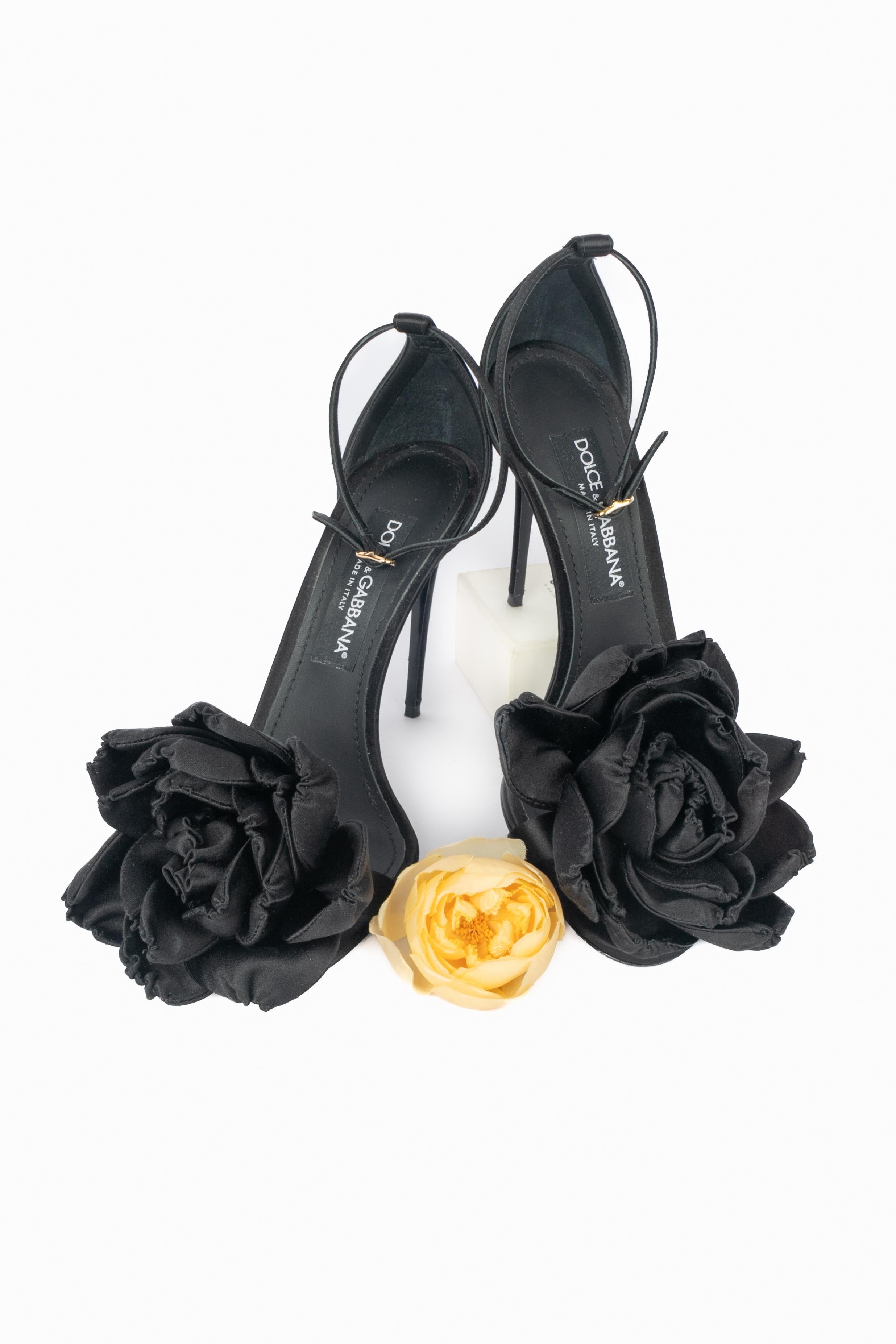 DOLCE & GABBANA - (Made in Italy) Stiletto neri aperti ornati da un fiore in tessuto satinato, una briglia alla caviglia e un logo della Maison in metallo dorato sul retro. Taglia 39.

Condizioni:
Ottime condizioni

Dimensioni:
Altezza del tacco: