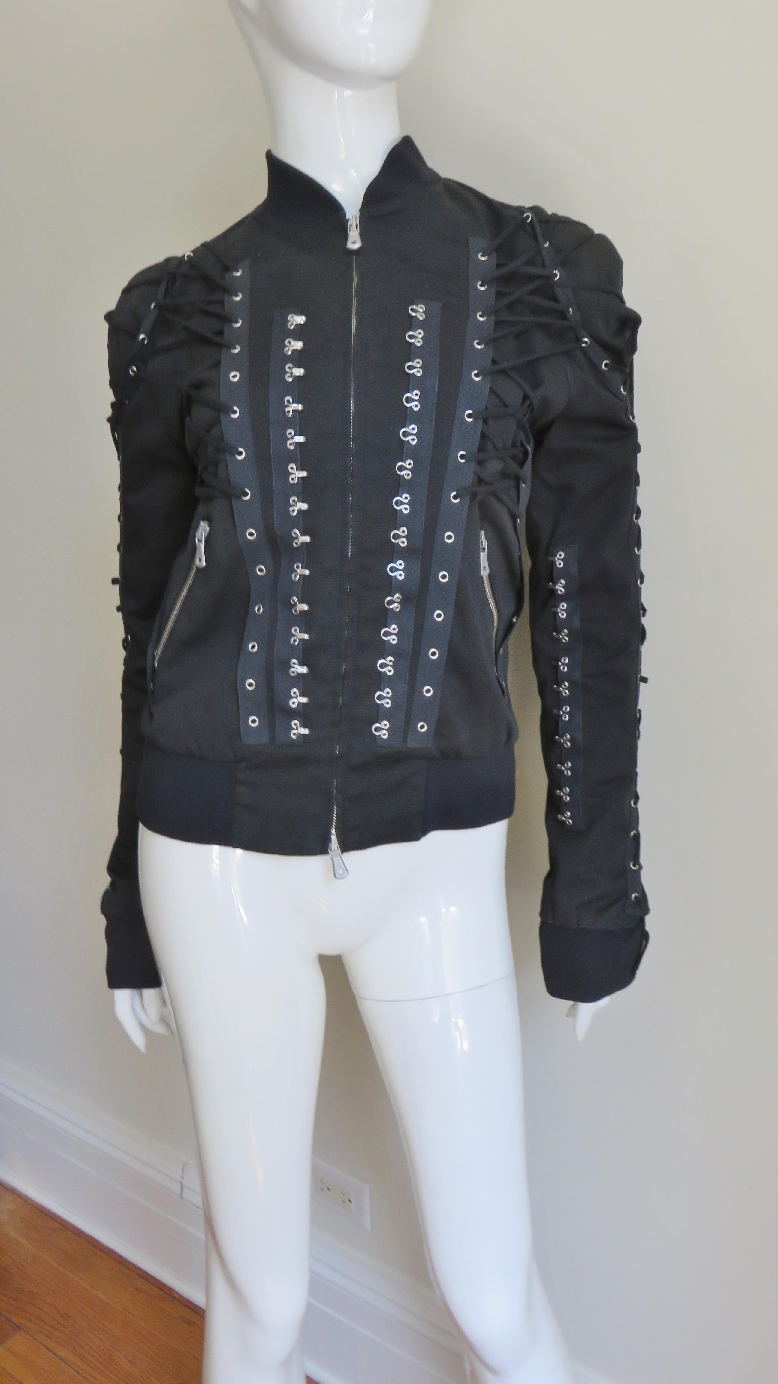 An incredible black cotton with a bit of stretch jacket from Dolce & Gabbana.  It has a silver front zipper with Dolce & Gabbana pulls and also on the angled front pockets.  It is stunning with it's amazing array of vertical functional lacing- along