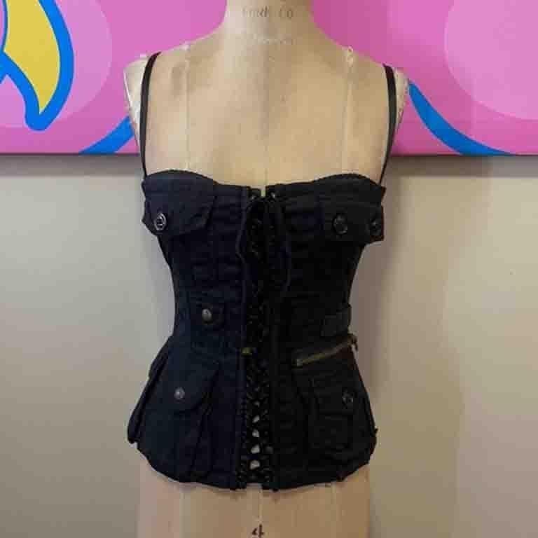 This rare vintage Dolce & Gabbana lace up corset / bustier in a military style is a wonder to behold. Unique zipper and pockets and lacing. Built in black satin bra. Adjustable straps.Pair with a black pencil skirt and heels for a super sexy look.