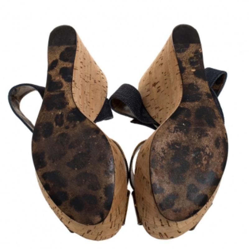 Estas impresionantes sandalias de cuña de Dolce & Gabbana están diseñadas para elevar tu look al instante. Llevan correas de charol para sujetar la parte delantera y correas vaqueras en los tobillos para sujetar bien los pies. Las sandalias se