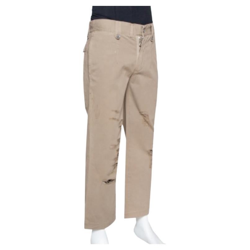 Flaunt casualwear in style with these cargo pants from Dolce & Gabbana. The light brown pants are tailored from cotton and carry a distressed design with front fastening and multiple pockets. The lightweight creation is well-made and comfortable to