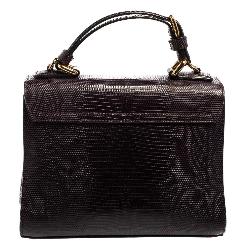 Well-structured and high on style, this Miss Monica bag from Dolce & Gabbana deserves to be yours! It has been crafted from lizard-embossed leather and styled with a top handle. It also comes with a gold-tone latch-lock flap that reveals insides