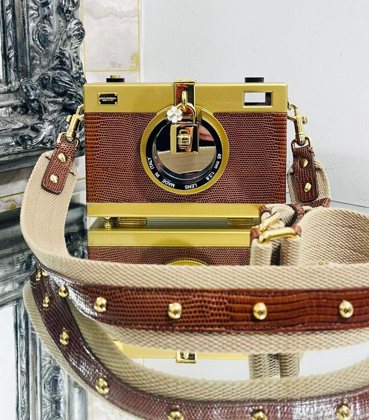 Rare Piece - Dolce & Gabbana Lizard Skin Camera Bag

Brown shoulder bag crafted  from exotic leather in a shape of a camera and designed with gold tone details and mirrored camera lens.

Having gold padlock attached embellished with white
